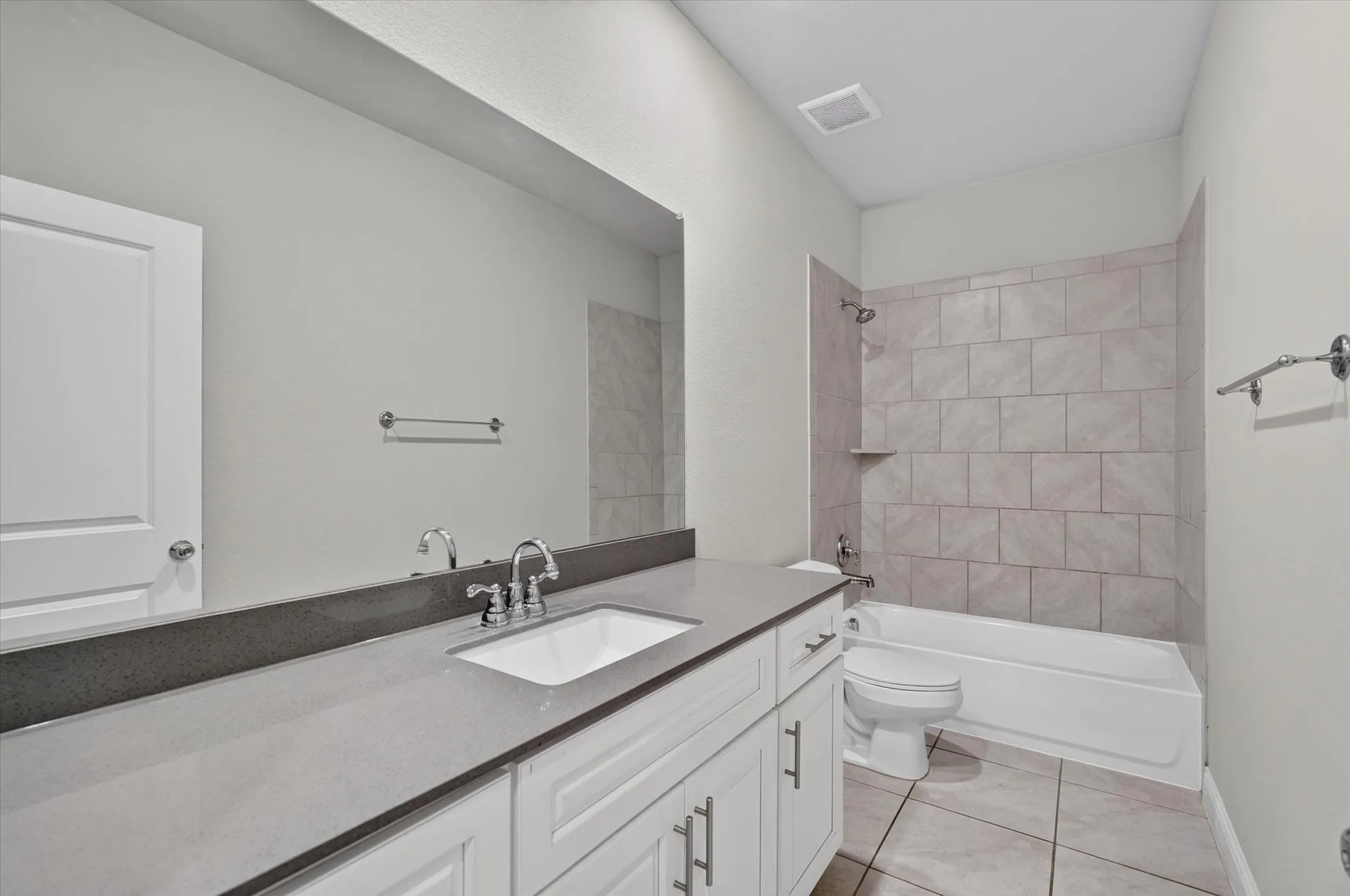 Modern bathroom featuring a white vanity with dual sink configuration, dark-finish countertop, and chrome fixtures