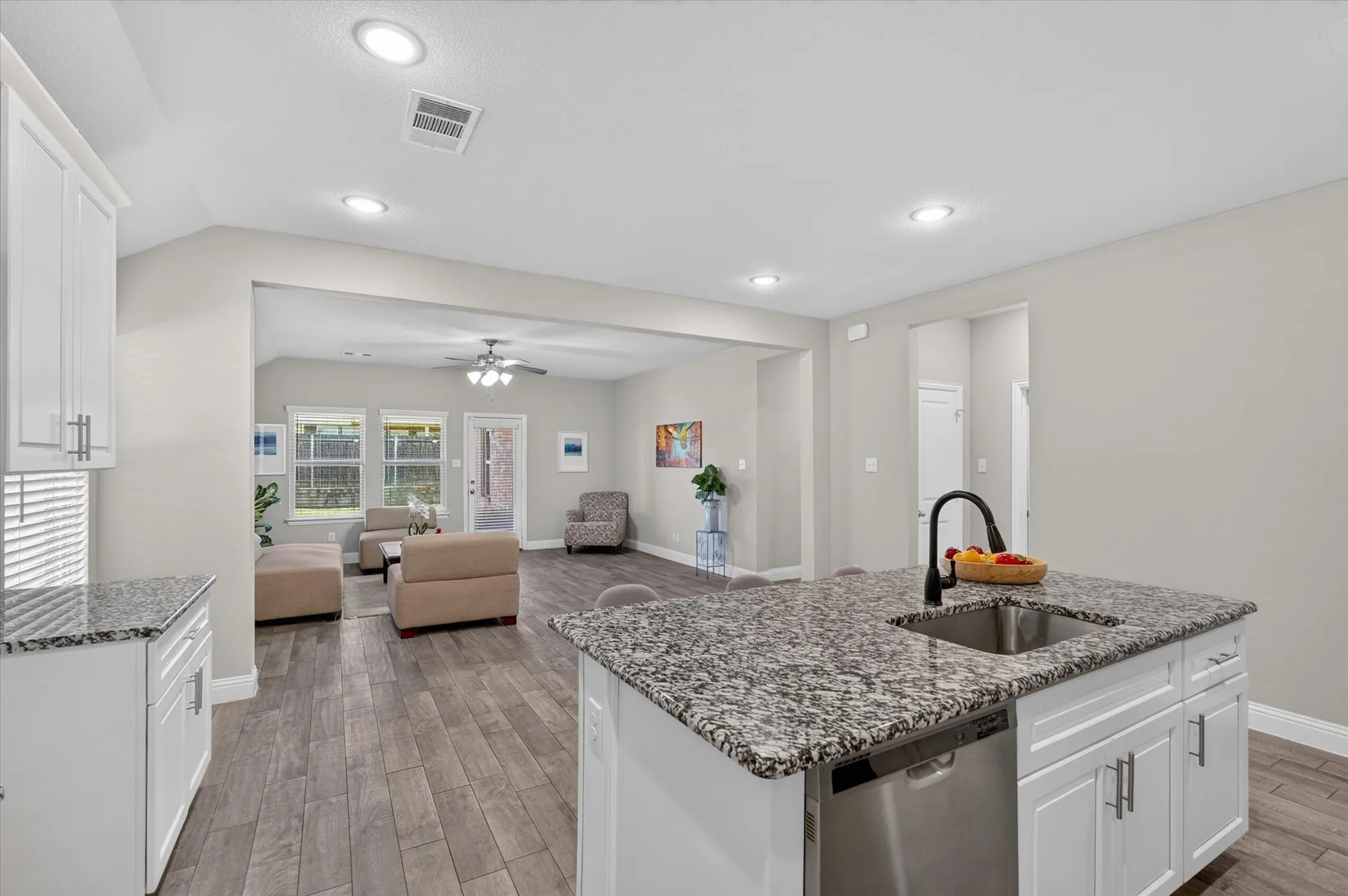 Kitchen island with an undermount sink, granite countertop, and stainless steel dishwasher
