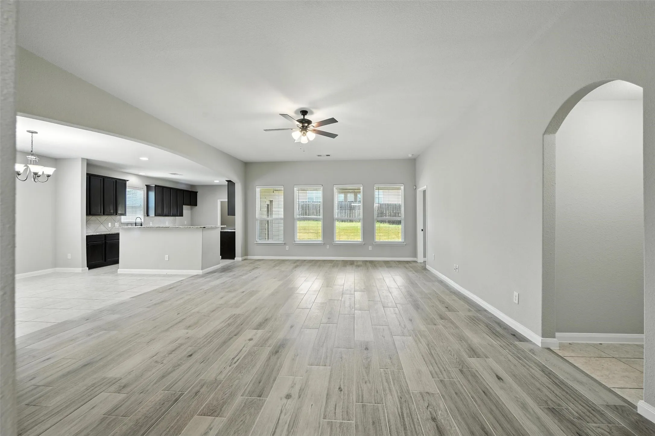 Open-concept living area with wood-finish flooring, recessed lighting, and a ceiling fan