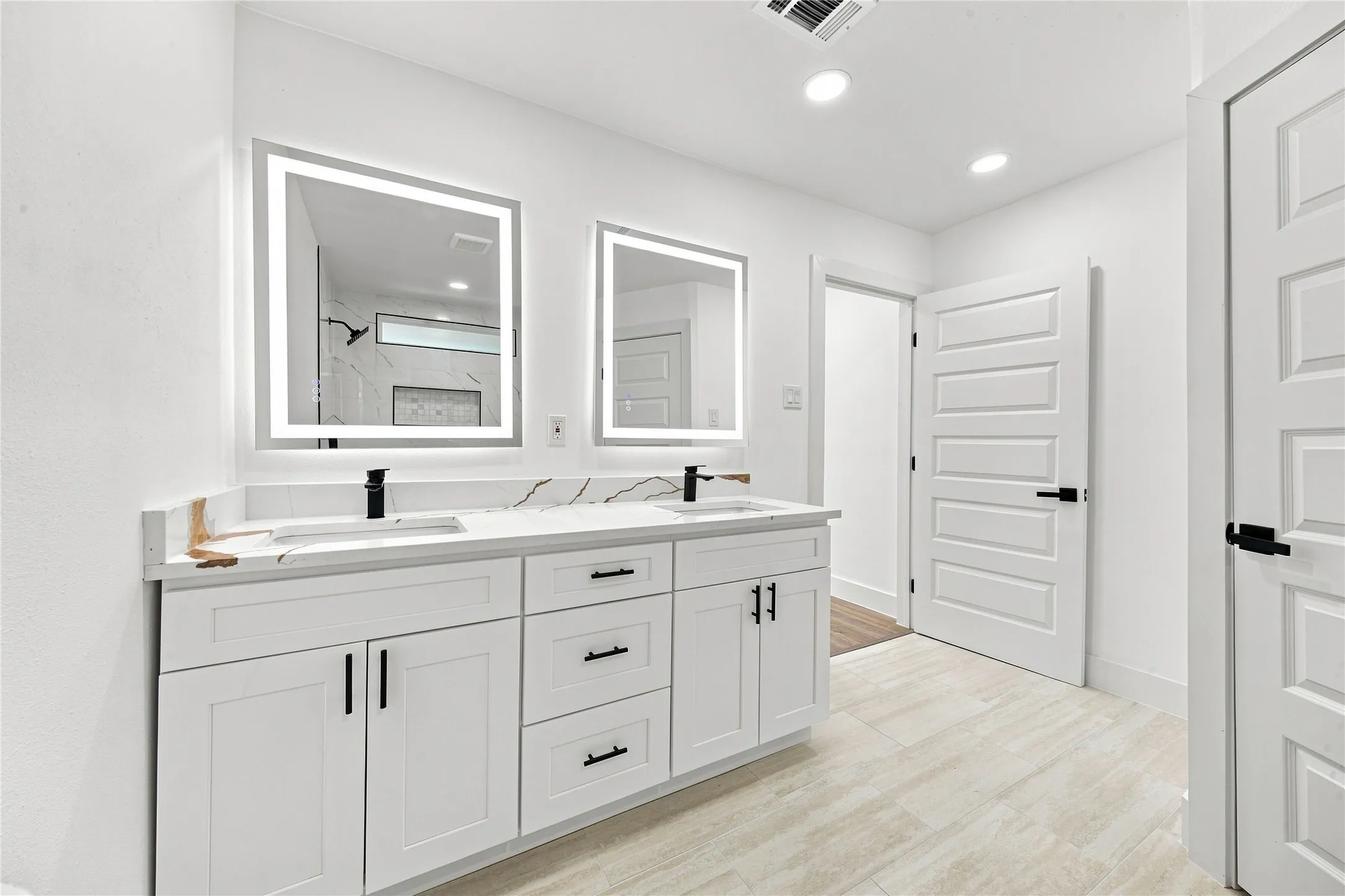 Dual vanity with white cabinetry and black hardware