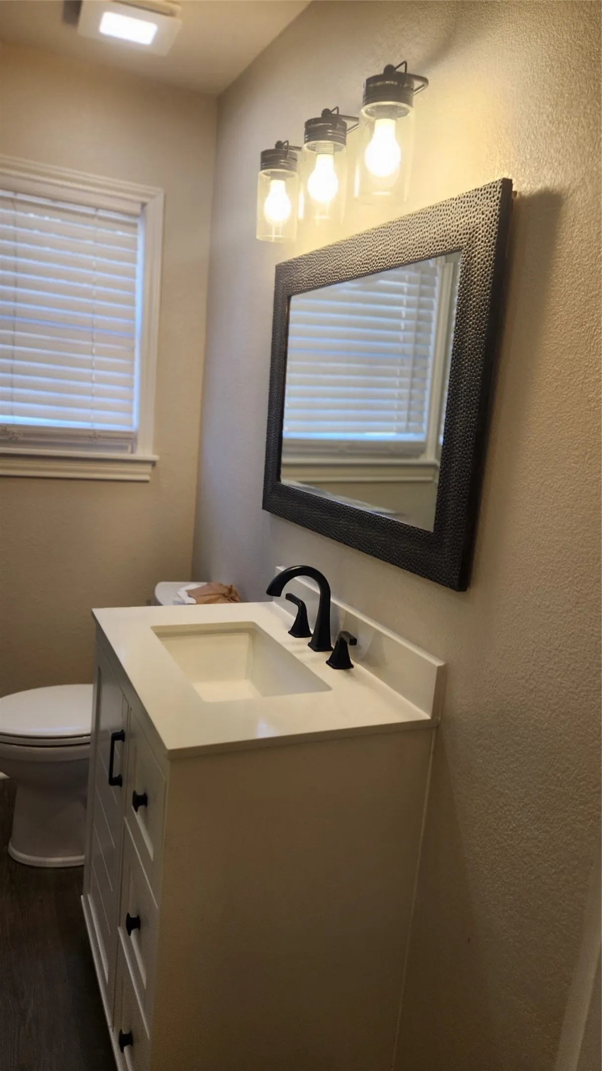 White vanity with shaker-style drawers, integrated sink, matte black faucet, and coordinating cabinet pulls