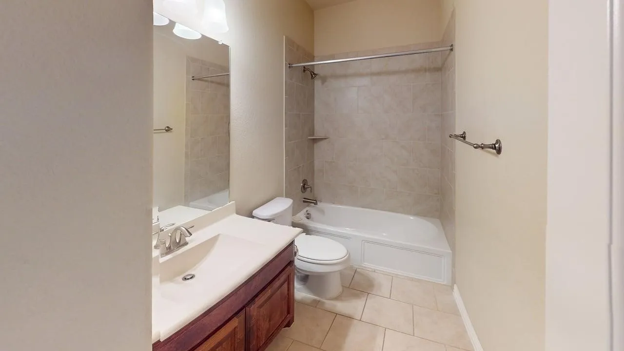 Vanity with wood-finish cabinetry, integrated sink, and dual-handle faucet