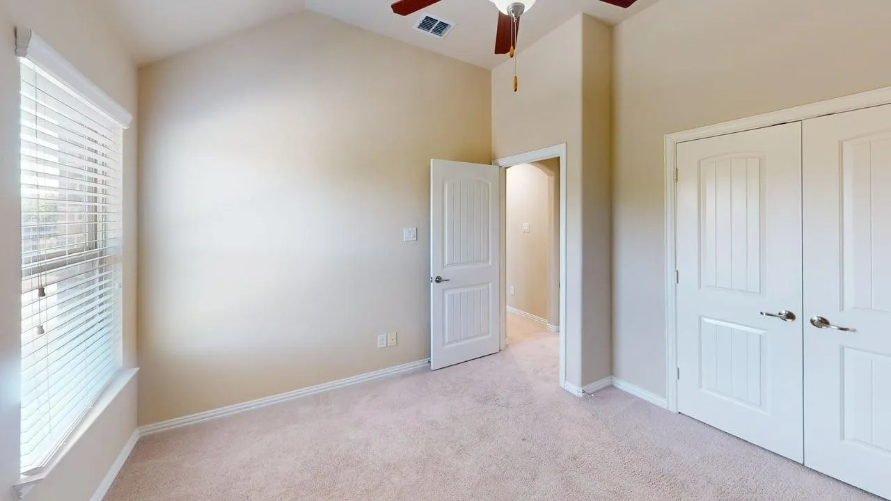 Vaulted ceiling, ceiling fan, carpeting, double closet doors, and interior door with hardware