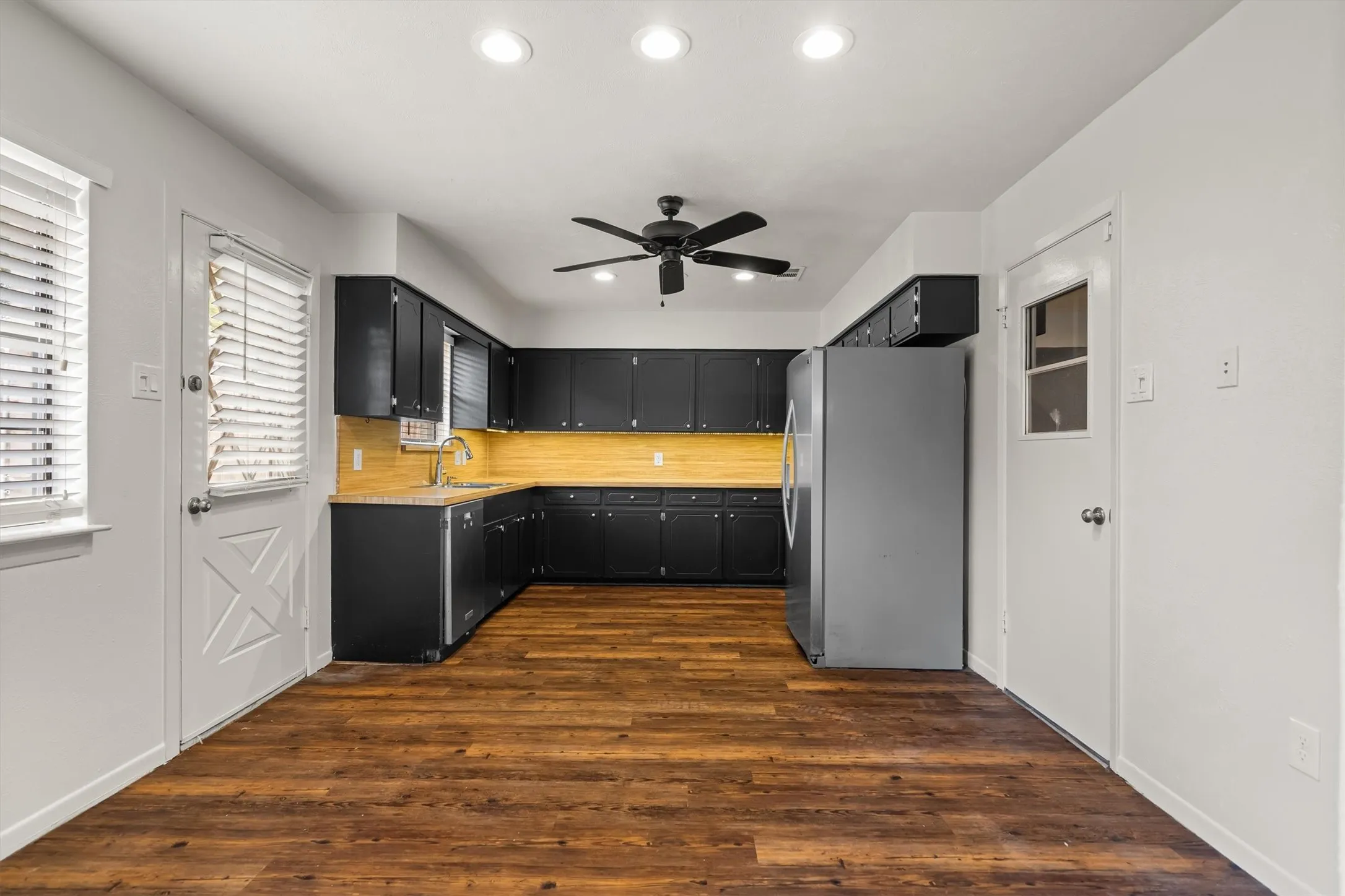 Kitchen featuring wood-look flooring, dark cabinetry, light countertops, and recessed lighting