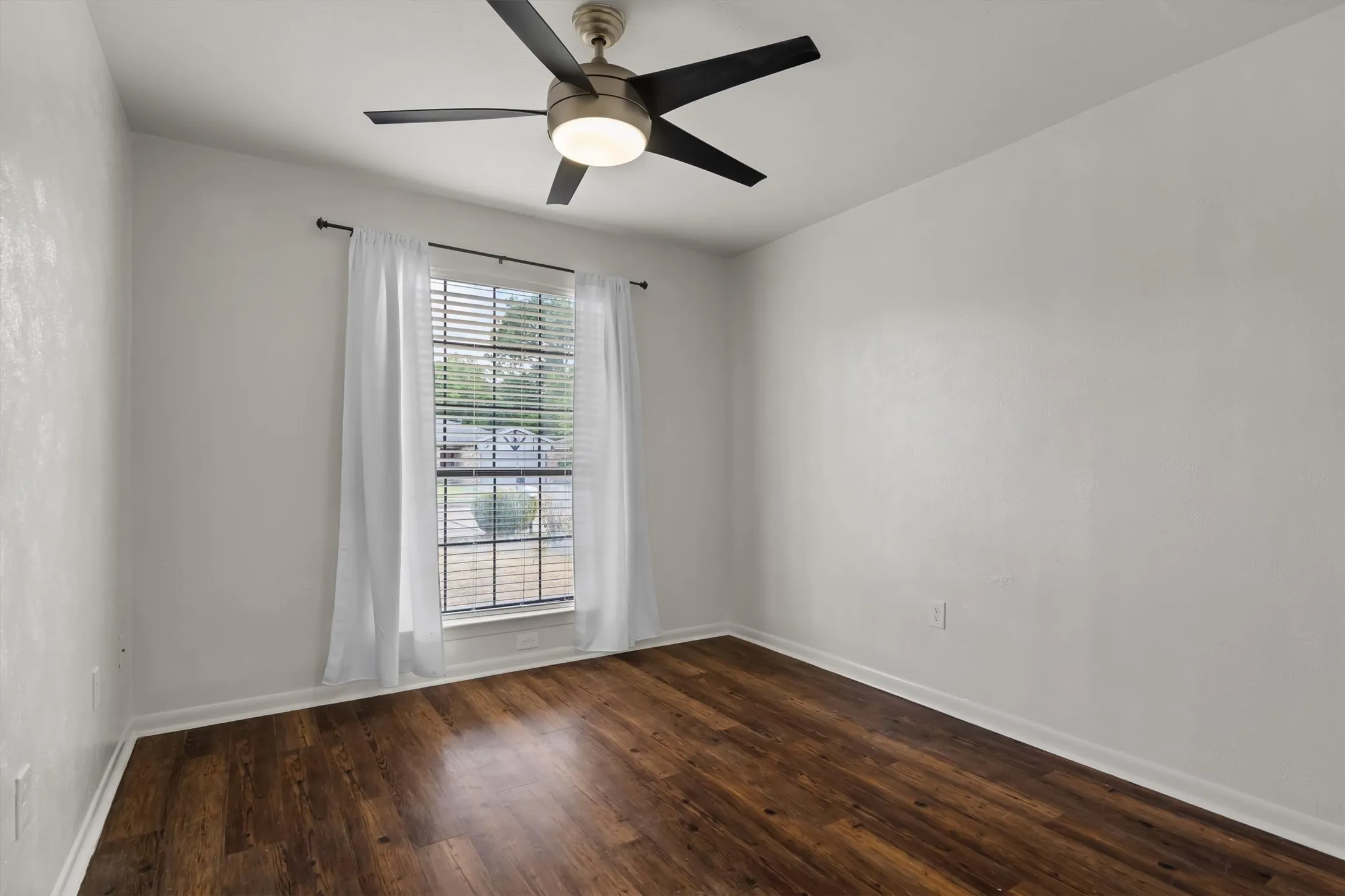 Wood-look flooring, neutral wall tones, and a window with blinds