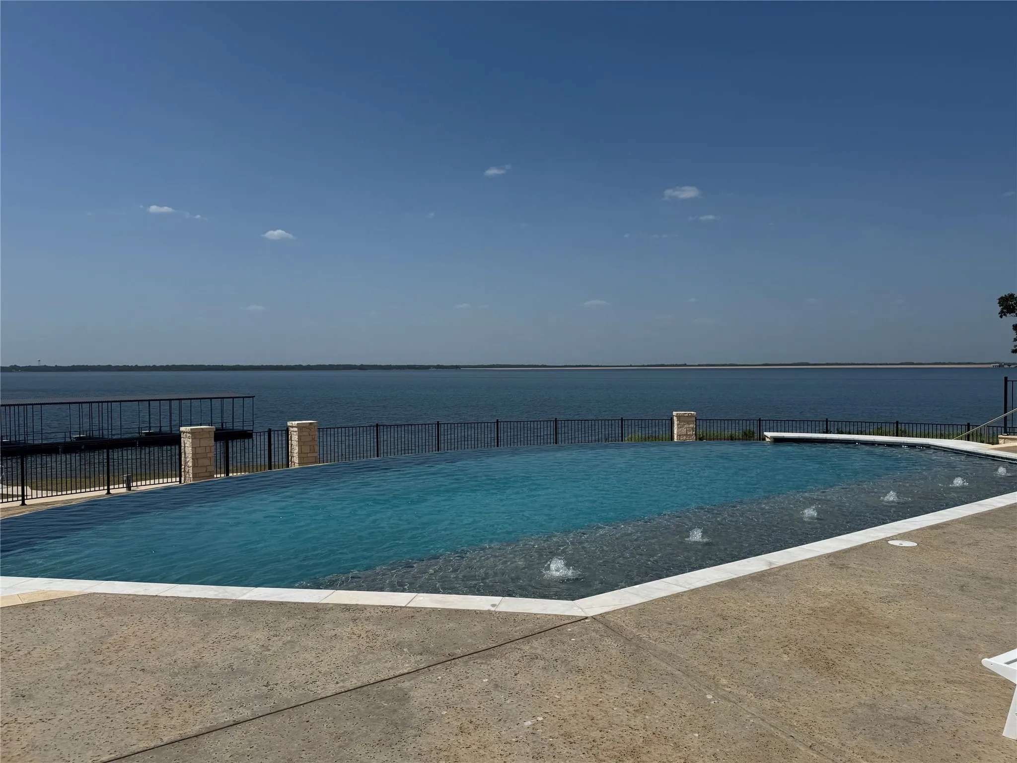 Infinity-edge swimming pool with integrated water features and a concrete pool deck