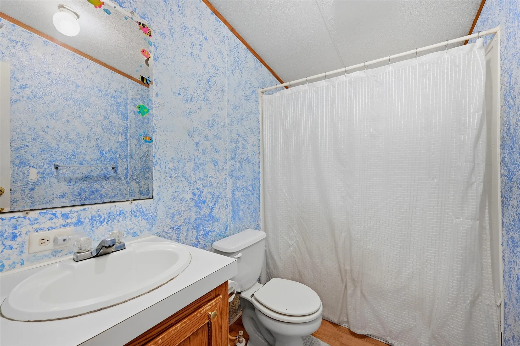 AI enhanced - Vanity with an integrated oval sink, wood-finish cabinetry, and a full-width mirror