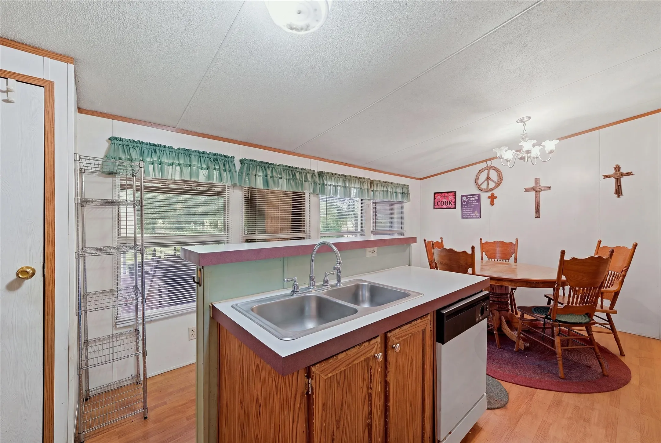 AI enhanced - Wood-finish flooring throughout, with a dual-basin stainless steel sink, built-in dishwasher, and wood cabinets