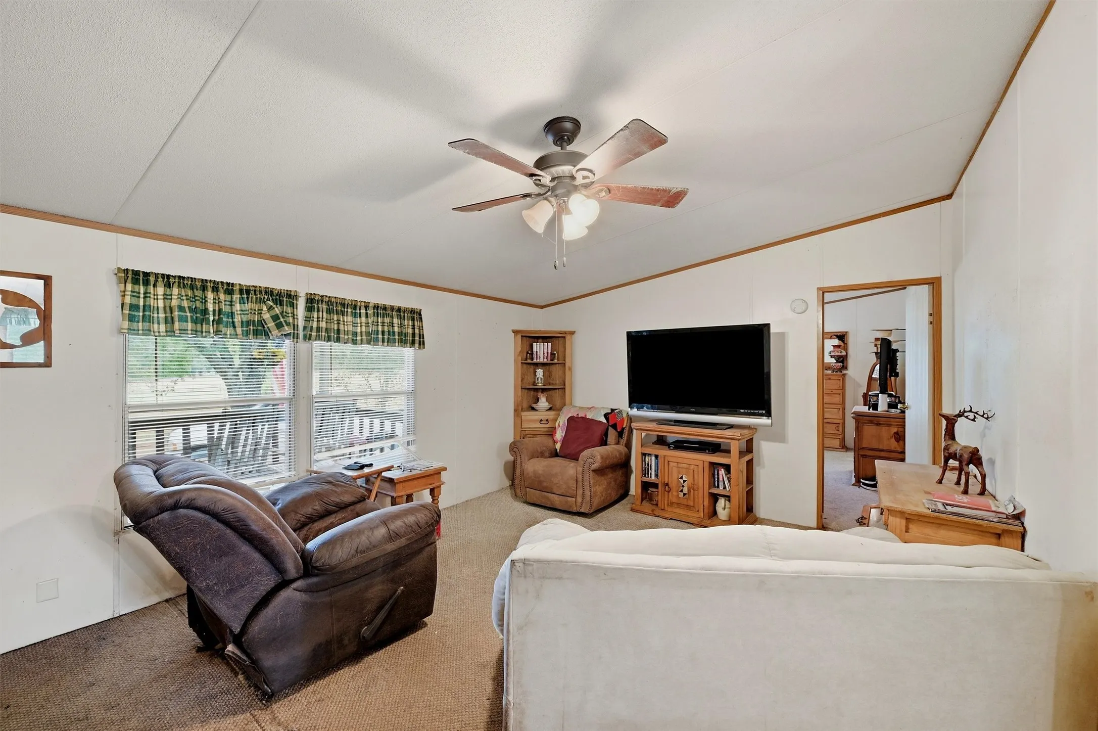 AI enhanced - Living area with sloped ceiling, wood-finish trim, and a ceiling fan with integrated lighting