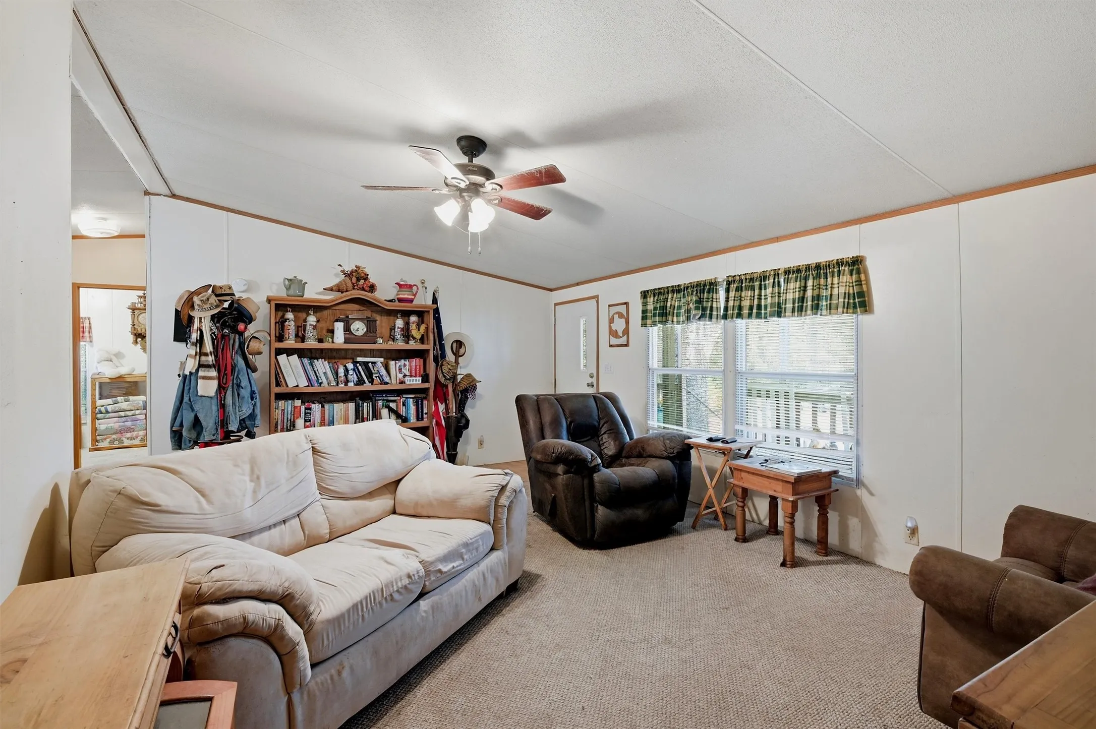 AI enhanced - Carpeted flooring, white wall paneling, ceiling fan, and a built-in bookshelf