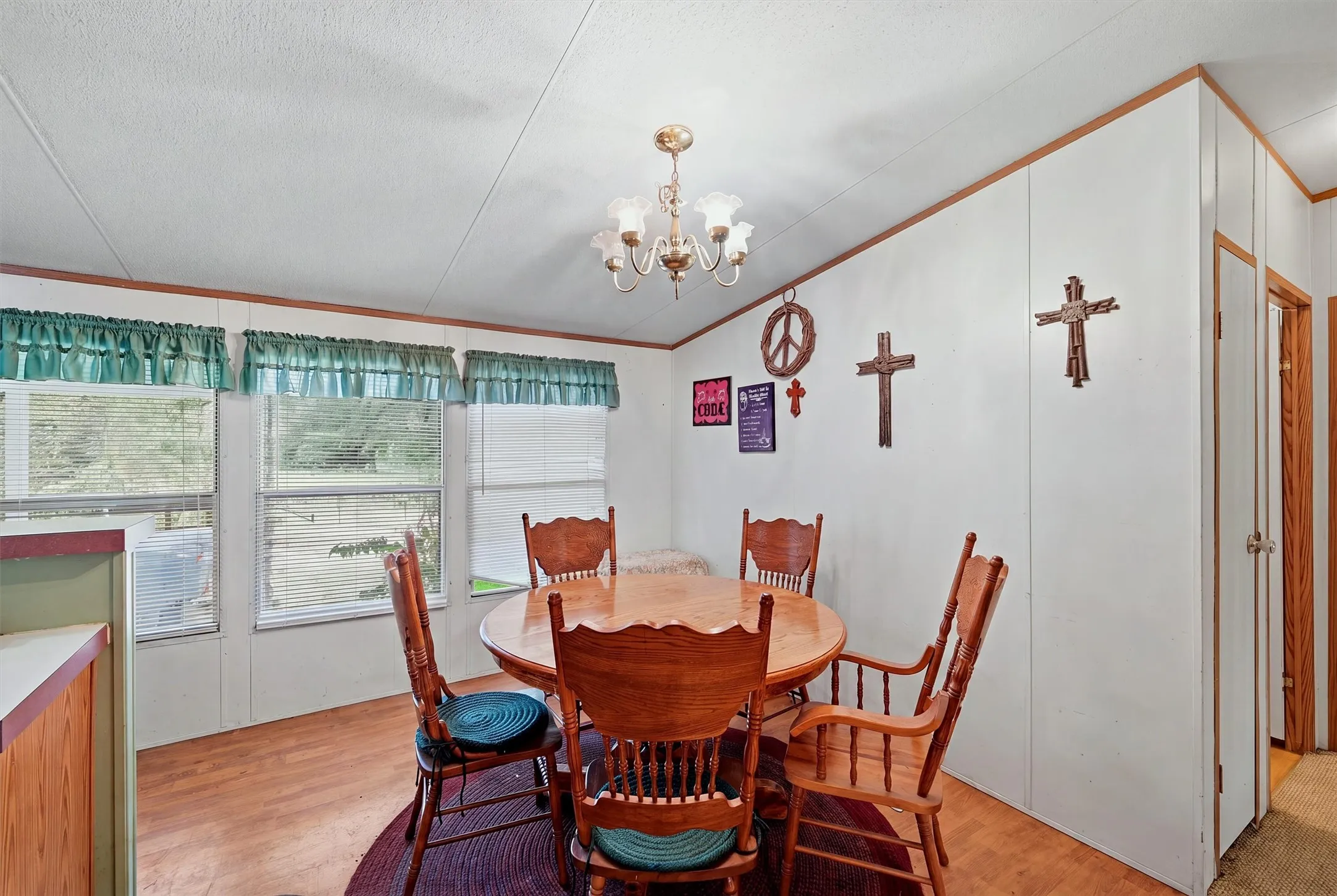 AI enhanced - Wood-finish flooring with a ceiling-mounted light fixture, multiple windows, and wood-toned trim