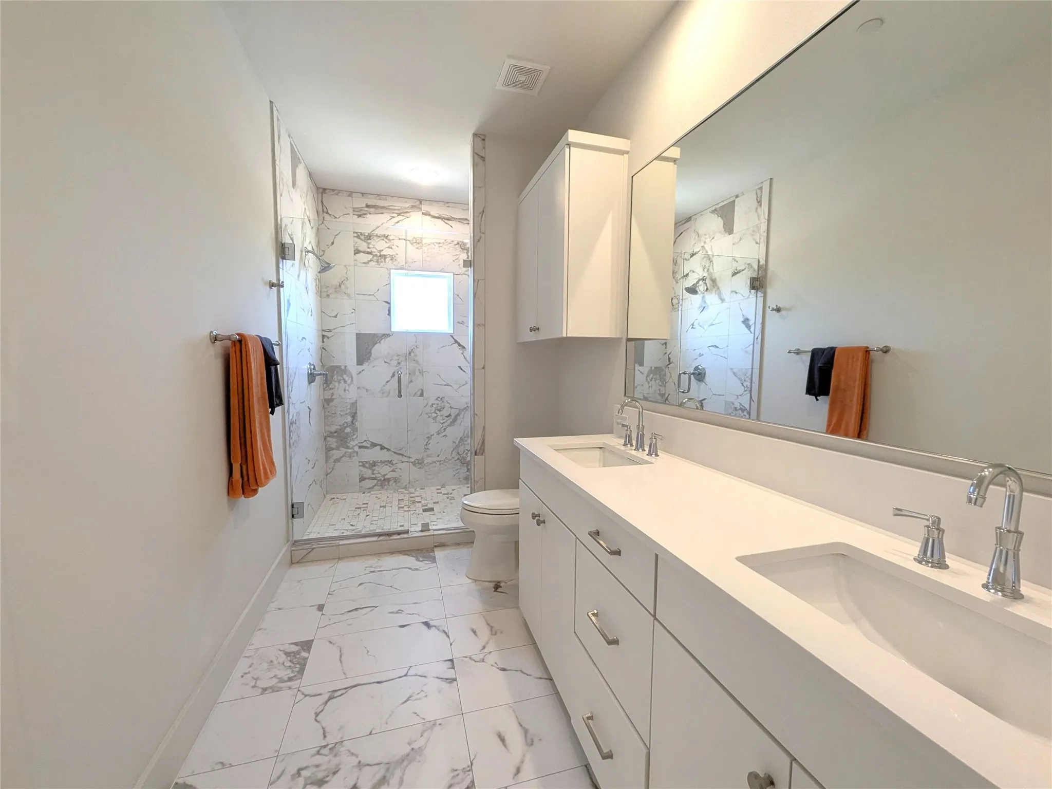 Dual vanity with integrated sinks, expansive counter space, and wall-mounted mirror