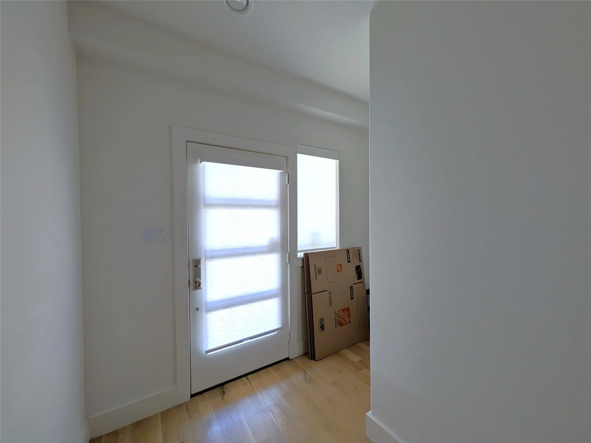 Entry door with frosted glass panels, wood-finish flooring, and a recessed ceiling light