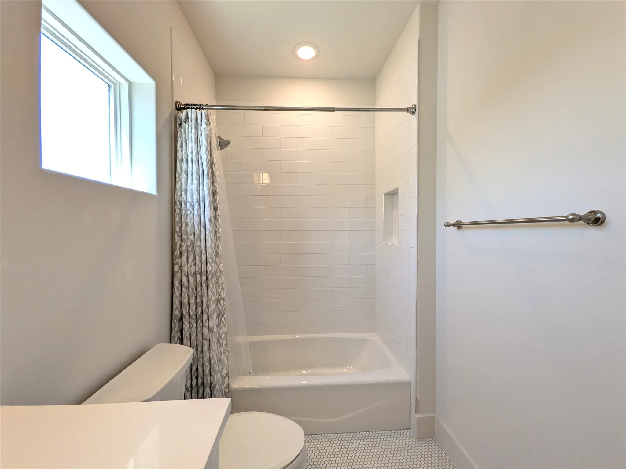 Recessed lighting, tile flooring, window, built-in shower niche, and subway tile shower surround