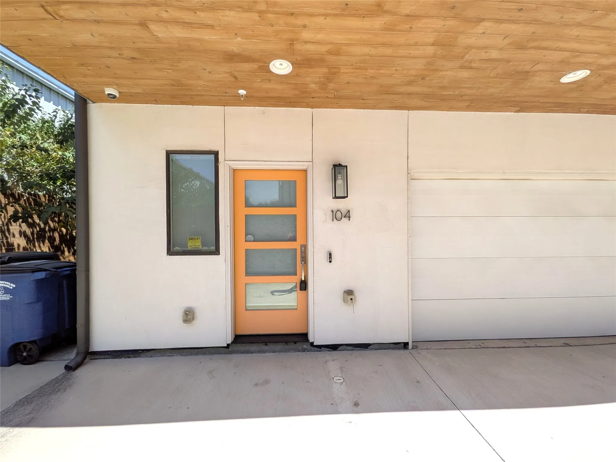 Contemporary exterior with a wood-finish soffit, recessed lighting, and a modern garage door