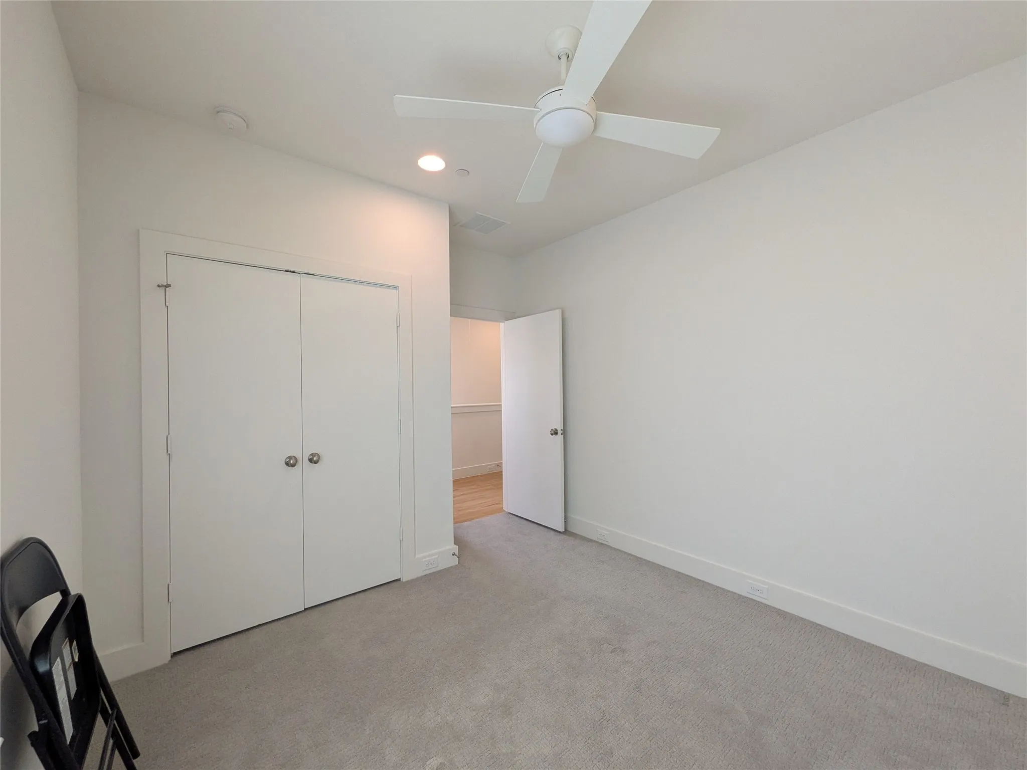 Neutral wall paint with recessed lighting, ceiling fan, and light grey carpet