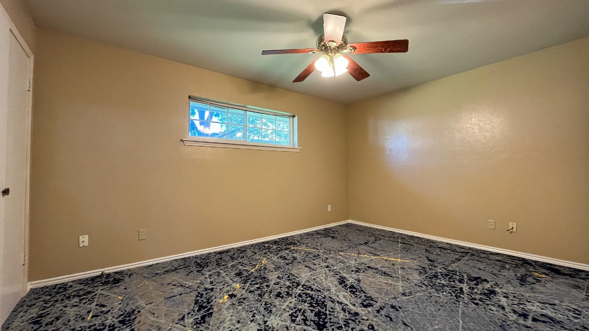 Ceiling fan with light fixture, window, and patterned flooring