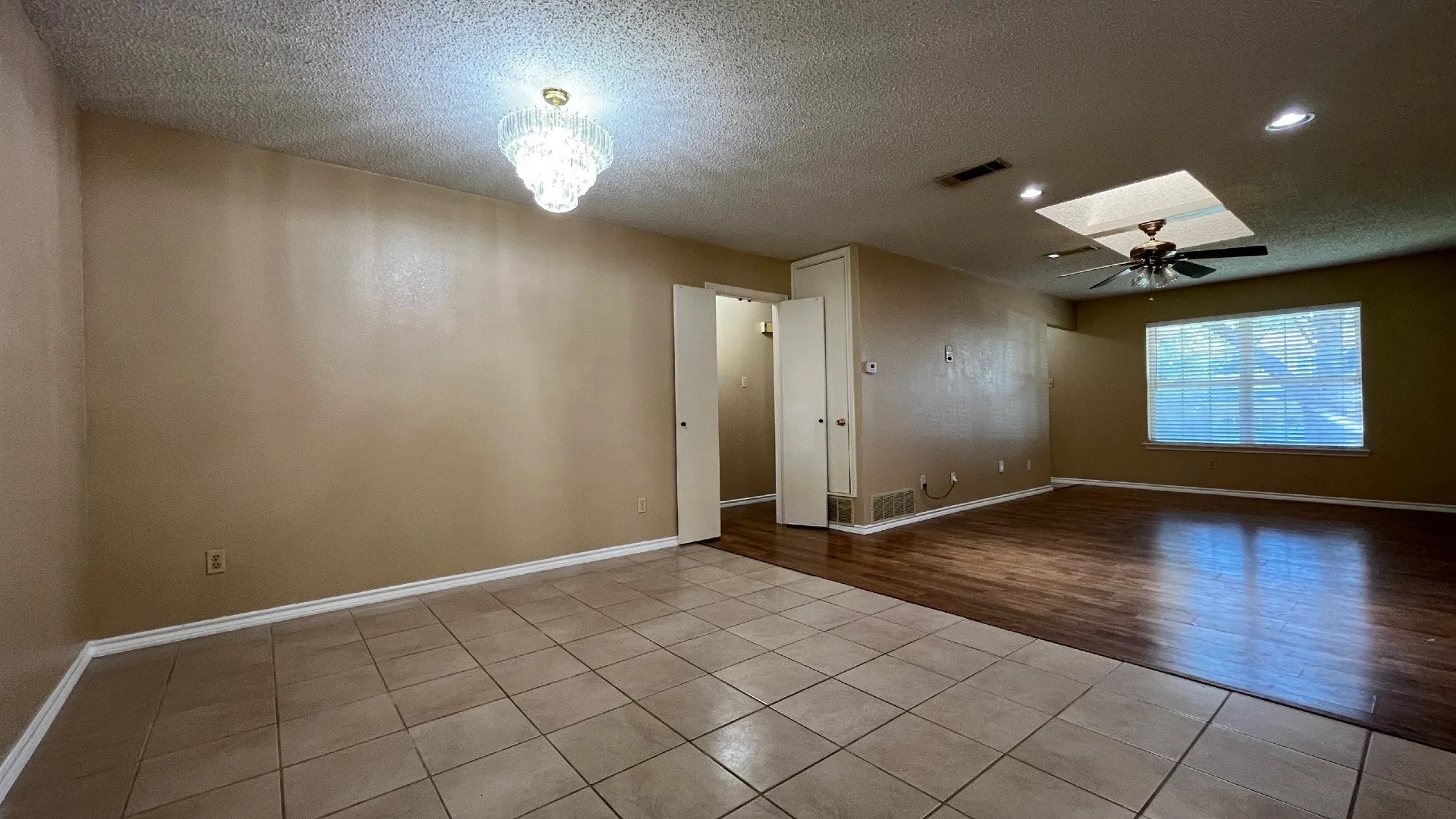 Mixed flooring featuring large square tiles and wood-finish planks