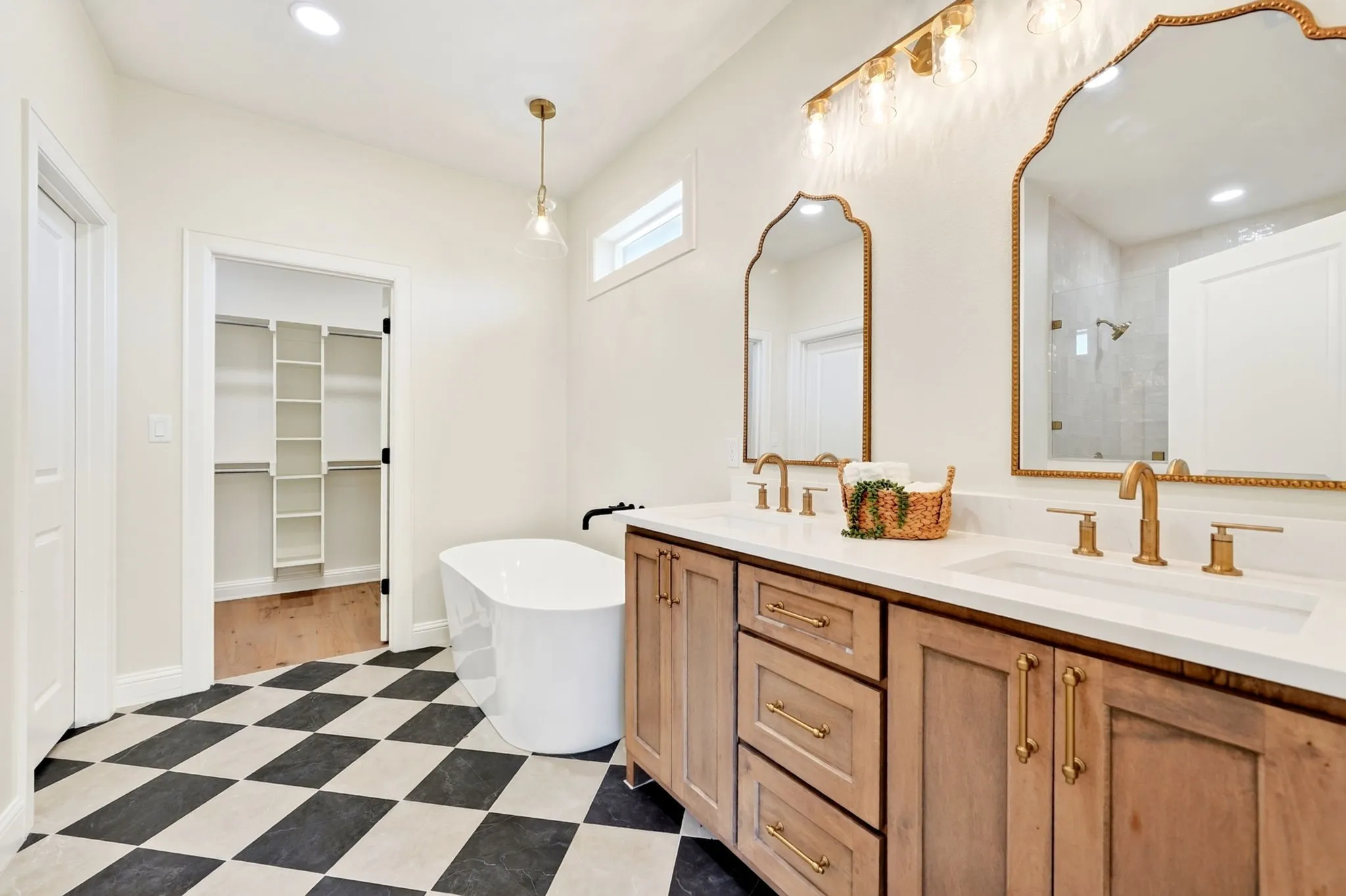 Primary bathroom featuring a stand alone soaking tub, walk-n tiled shower & walk-in closet.