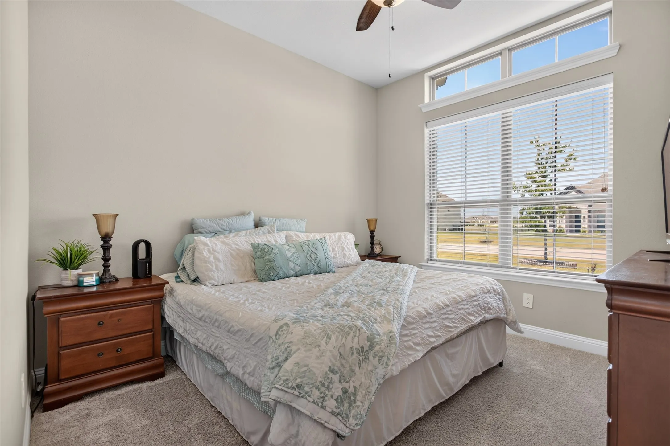 Tall ceilings, large windows with blinds, transom windows, neutral wall color, and a ceiling fan