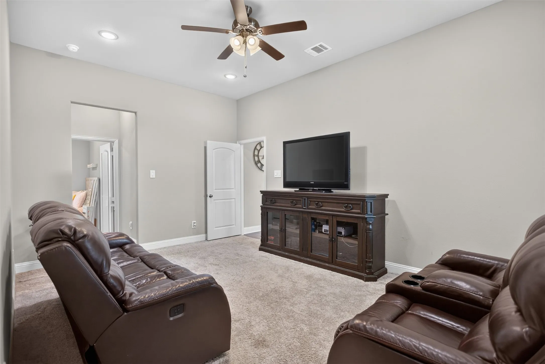 Recessed lighting, ceiling fan, neutral wall paint, and carpeted flooring
