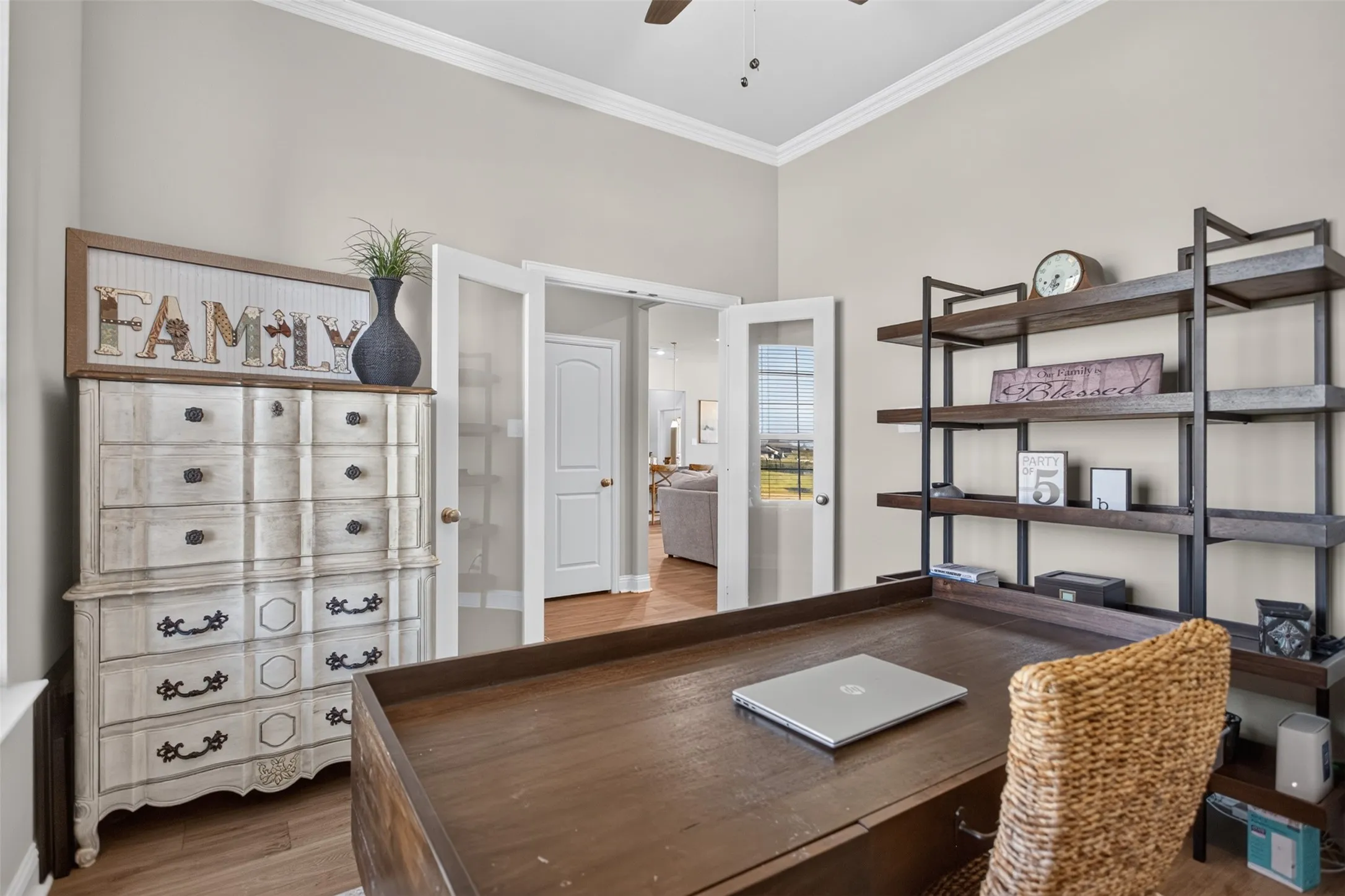 Vaulted ceiling, crown molding, wood-finish flooring, glass-panel French doors, built-in shelving
