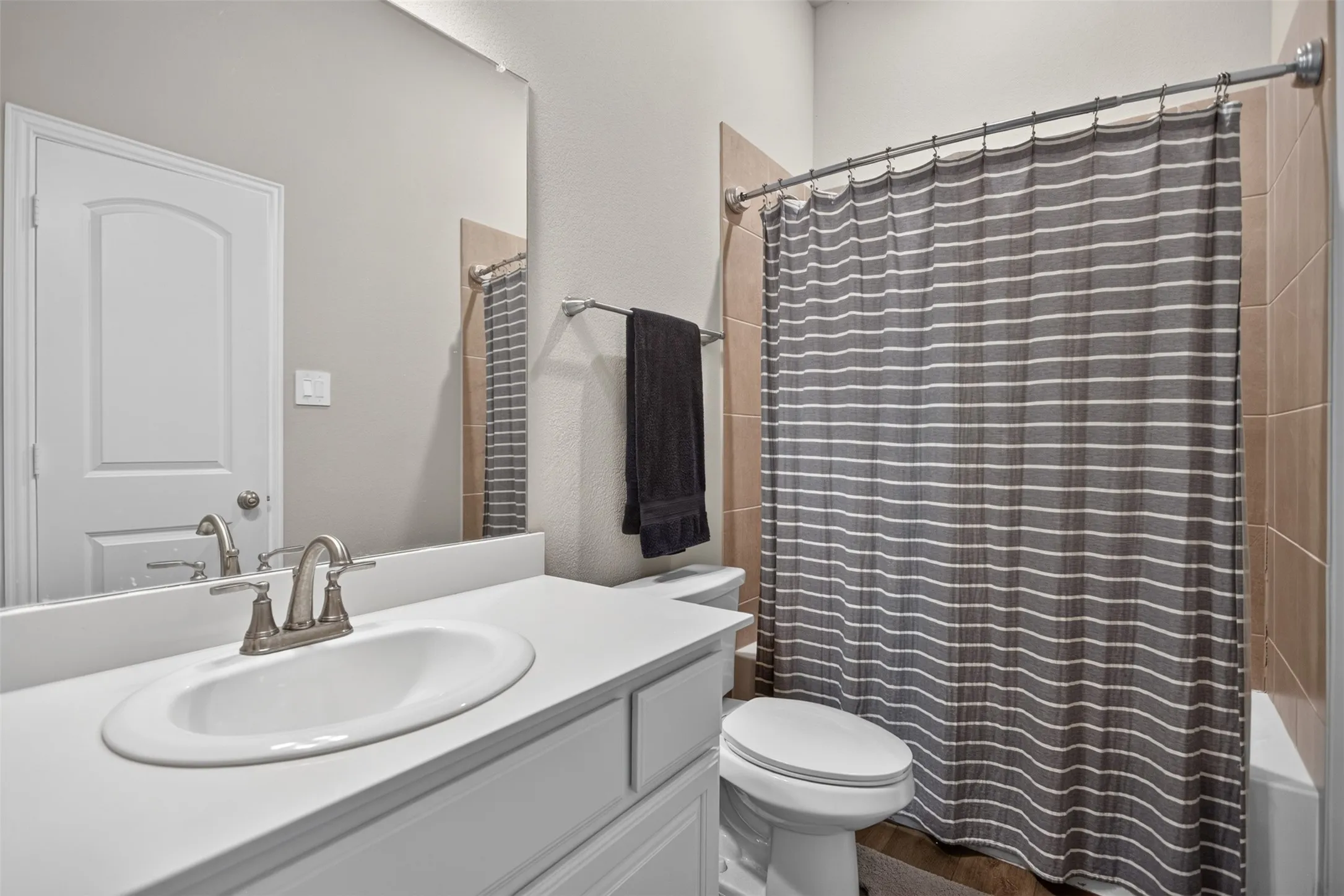 Vanity with an integrated oval sink and brushed nickel faucet