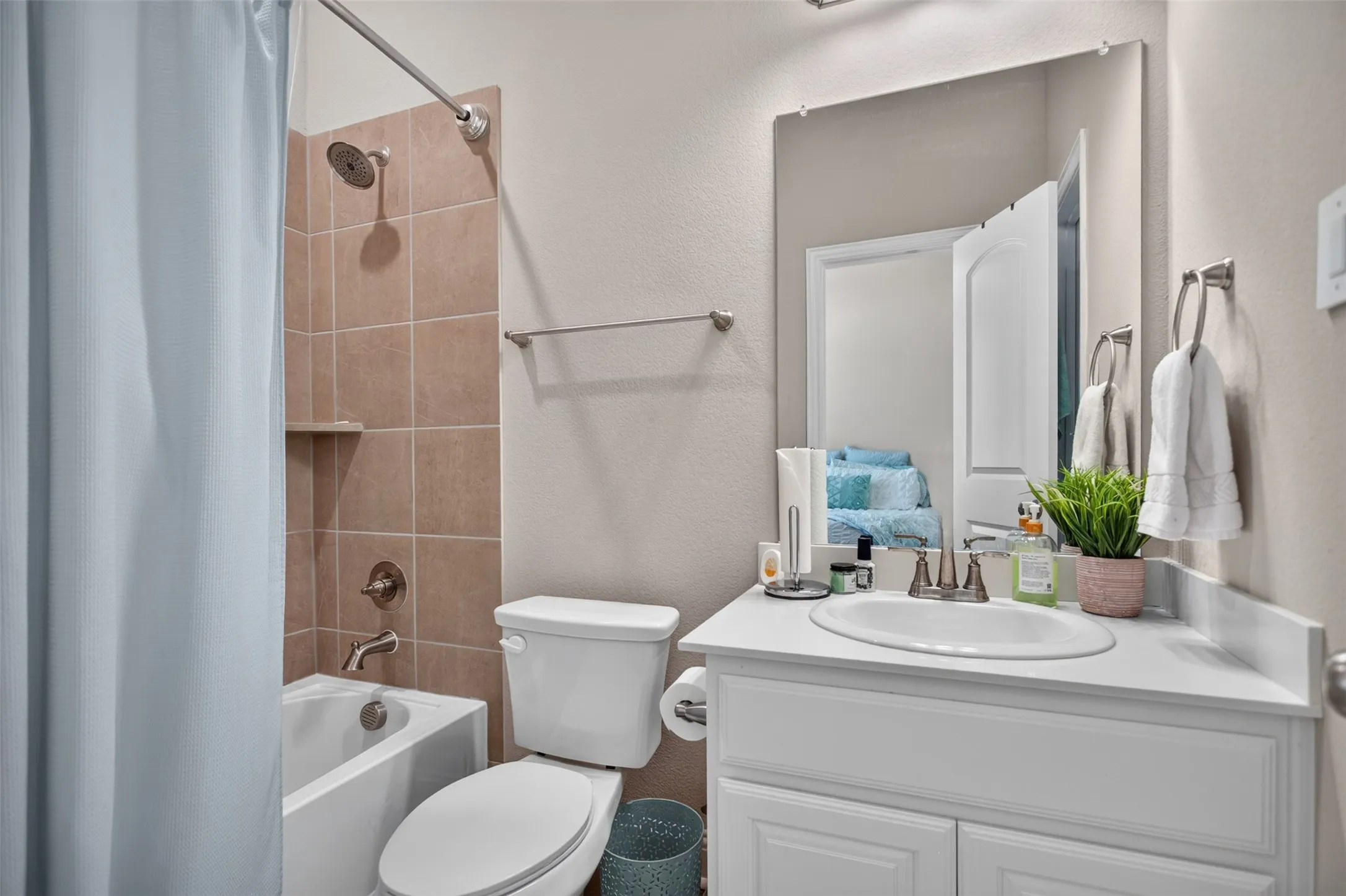 White vanity with built-in sink, wall-mounted mirror, and brushed nickel fixtures