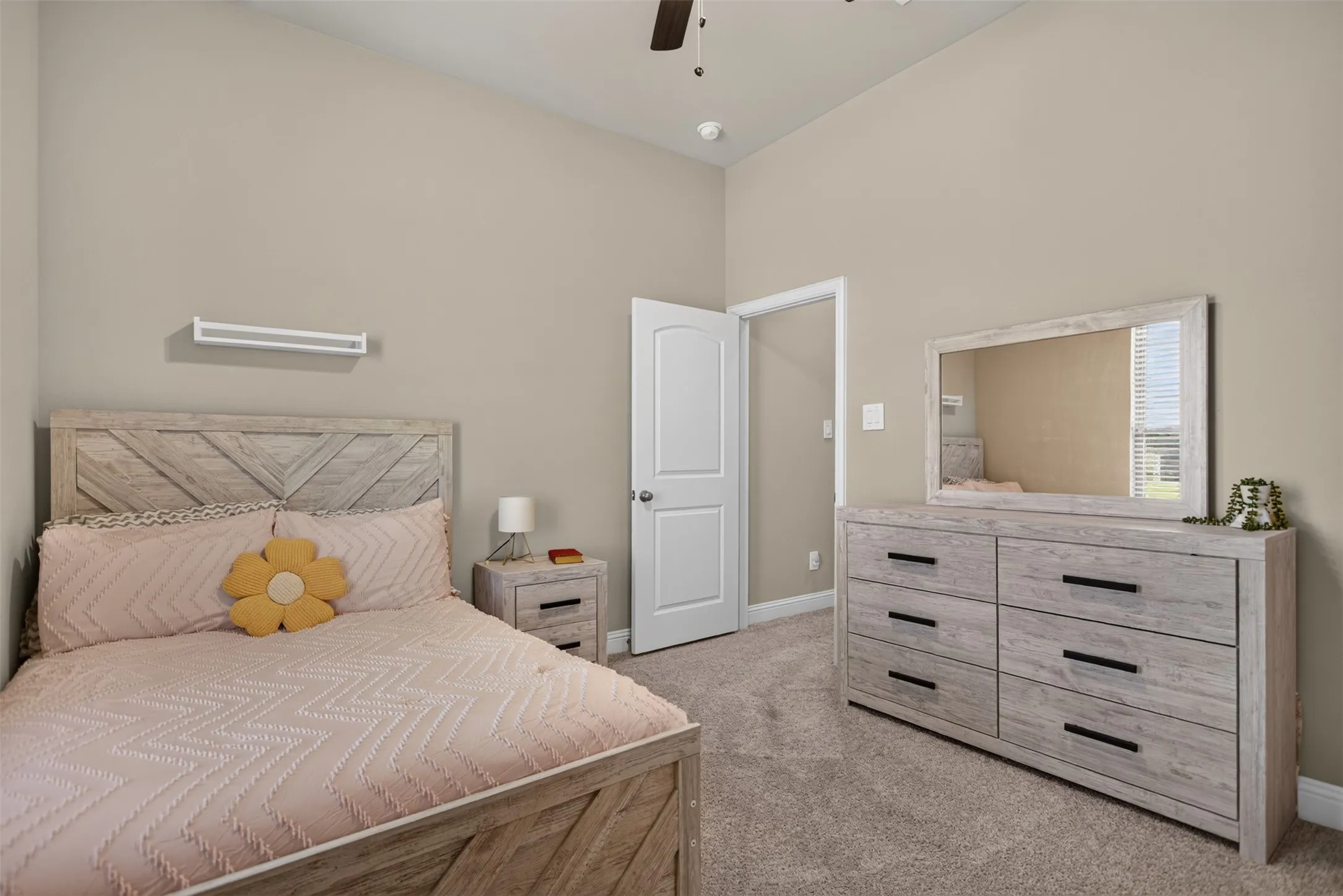 Vaulted ceiling with a ceiling fan, neutral wall paint, white trim, and light-colored carpeting