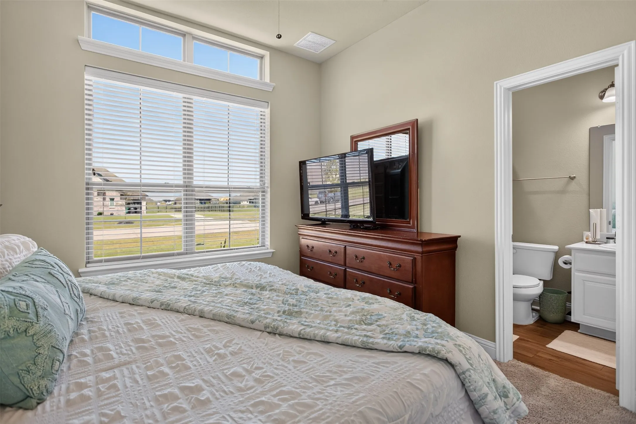 Room featuring a large window, transom window, and vaulted ceiling