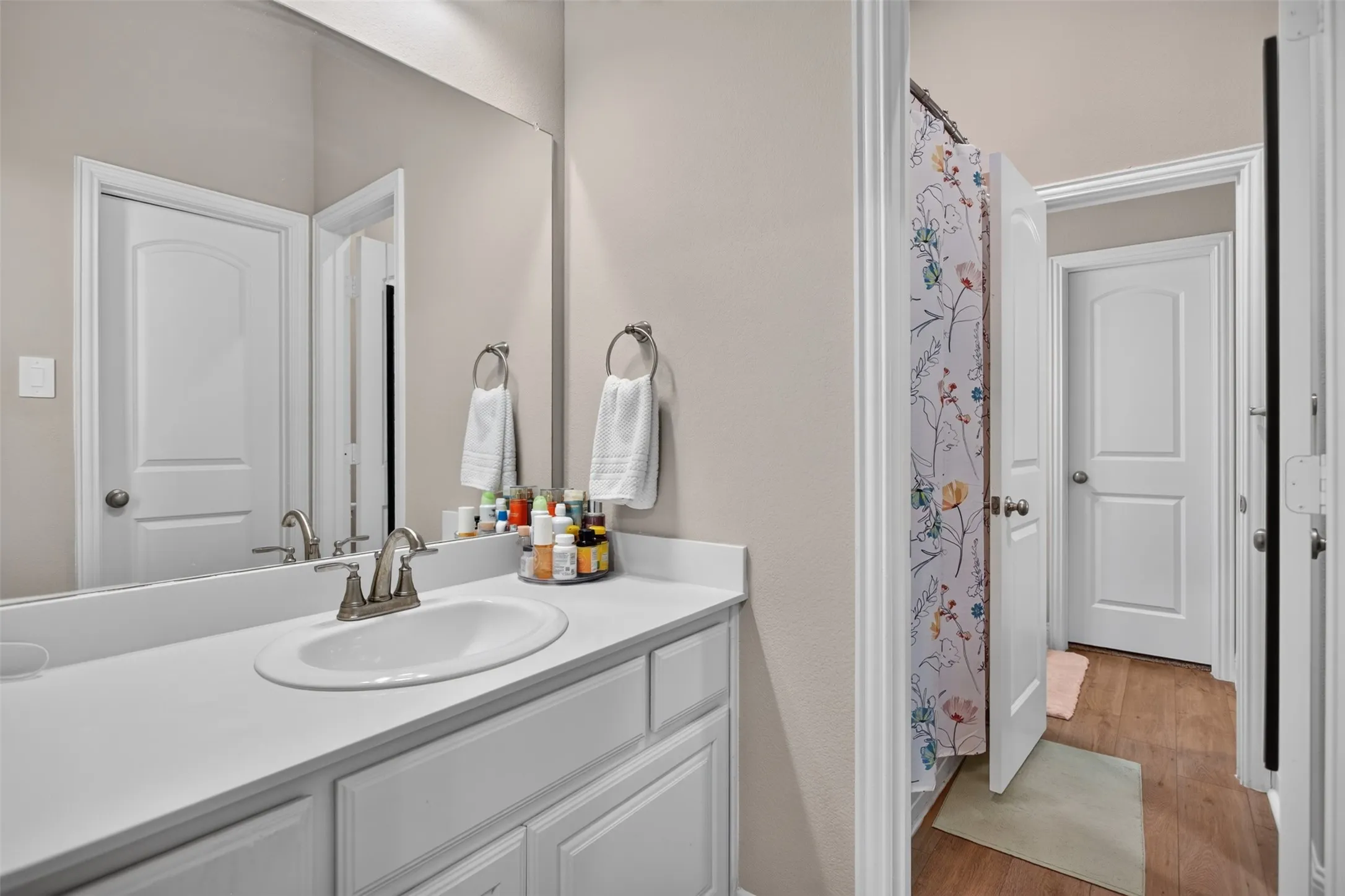 Vanity with an integrated oval sink, brushed nickel faucet, and a large wall-mounted mirror
