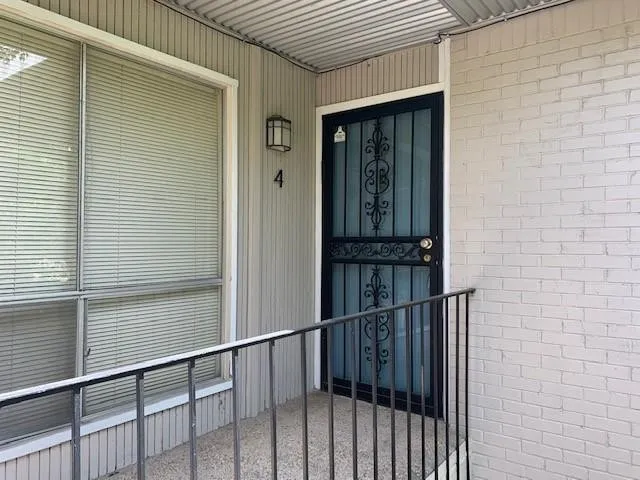 Painted brick exterior with corrugated metal awning and wall-mounted lighting fixture