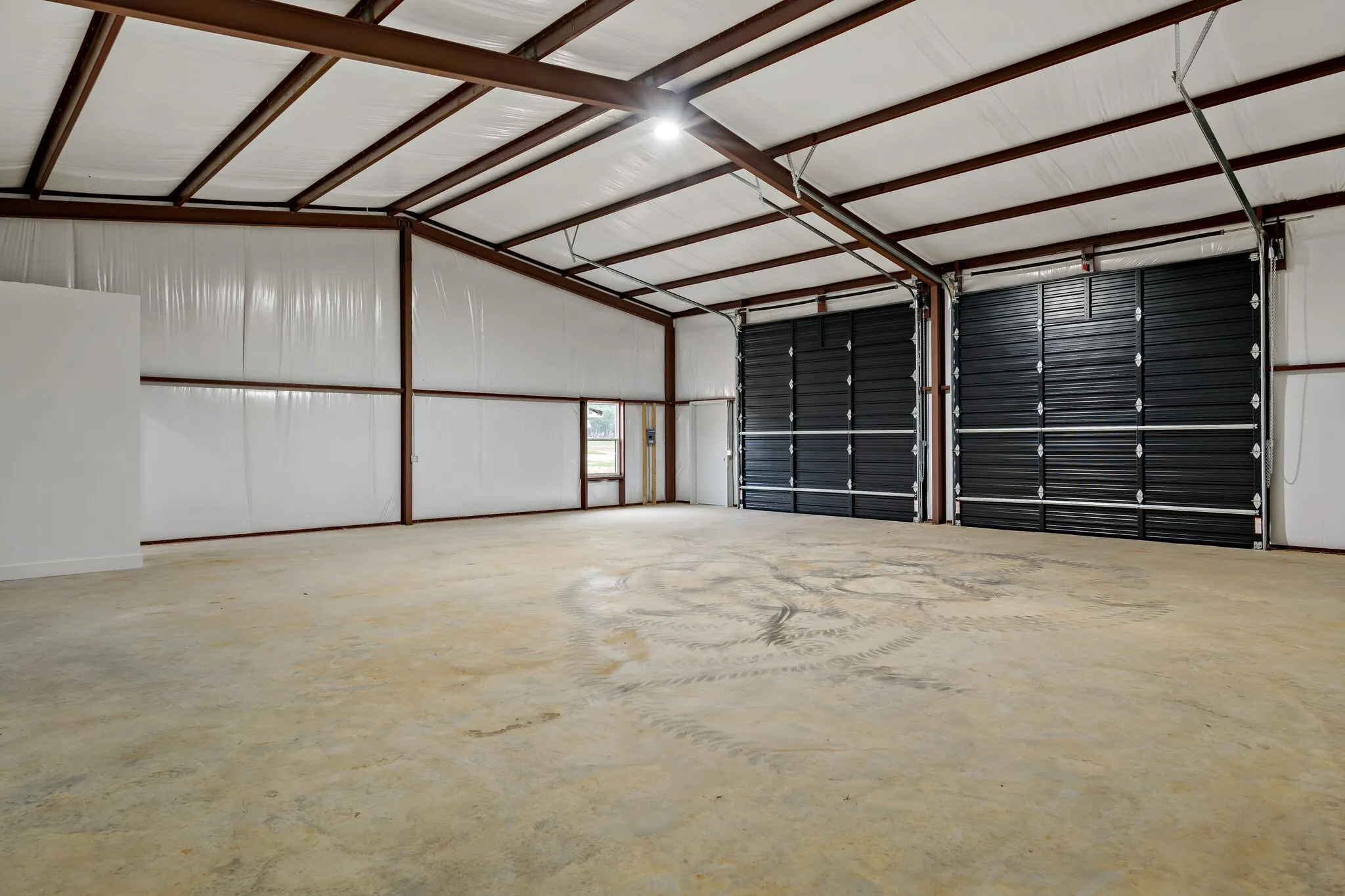 Expansive open interior with concrete flooring and exposed structural beams