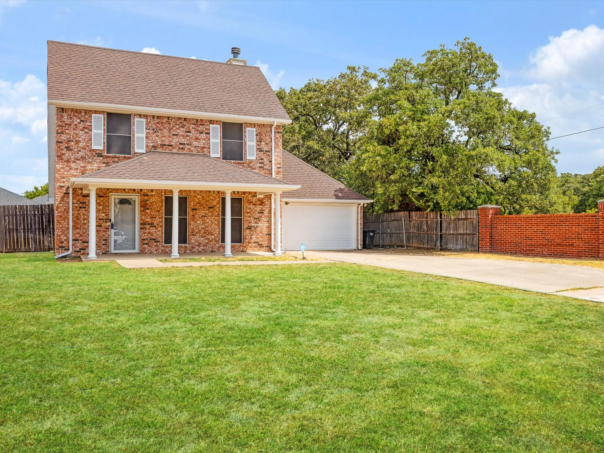 Brick exterior with a covered front porch featuring white columns