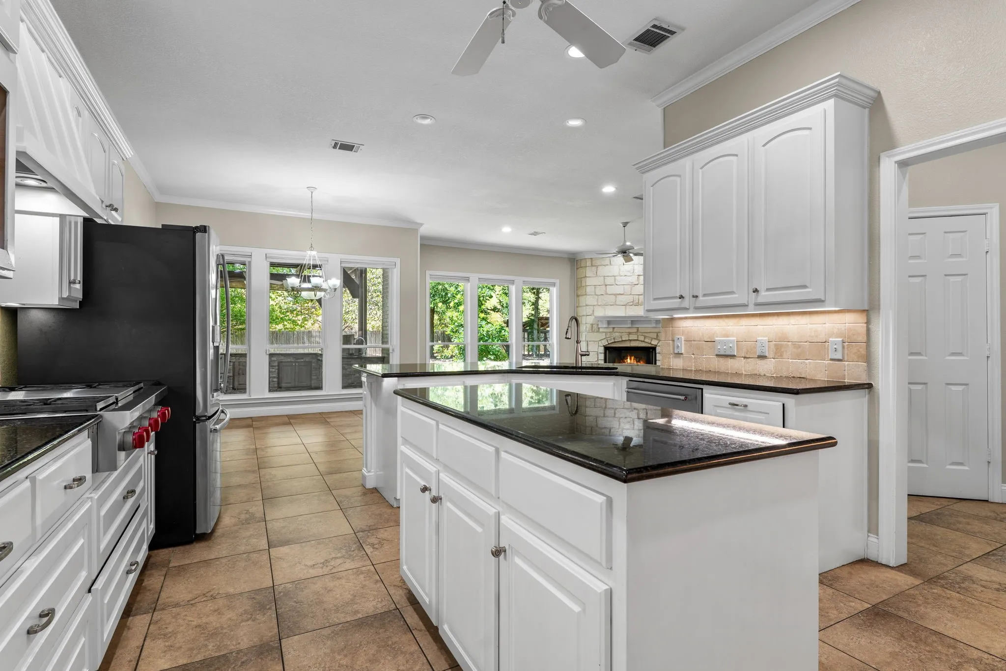 White cabinetry with dark countertops, stainless steel appliances, tile flooring, and recessed lighting