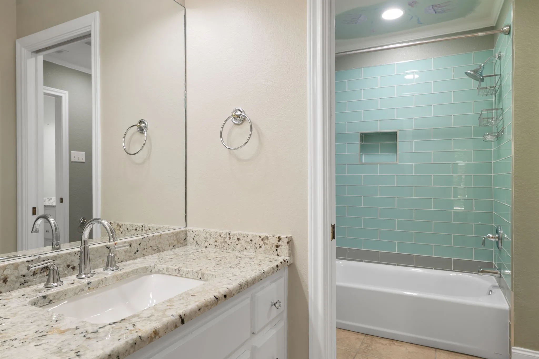 Granite vanity countertop with an undermount sink, chrome faucet, and full-width mirror