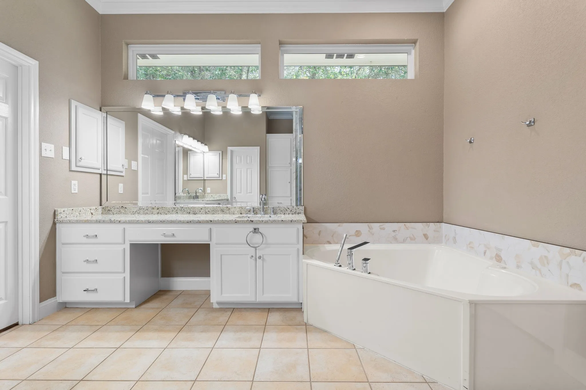 Dual vanity with white cabinetry, granite-style countertop, and integrated sinks