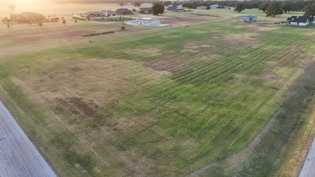 Expansive lot featuring a large grassy area and paved road access