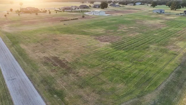 Expansive grassy land with an asphalt surface