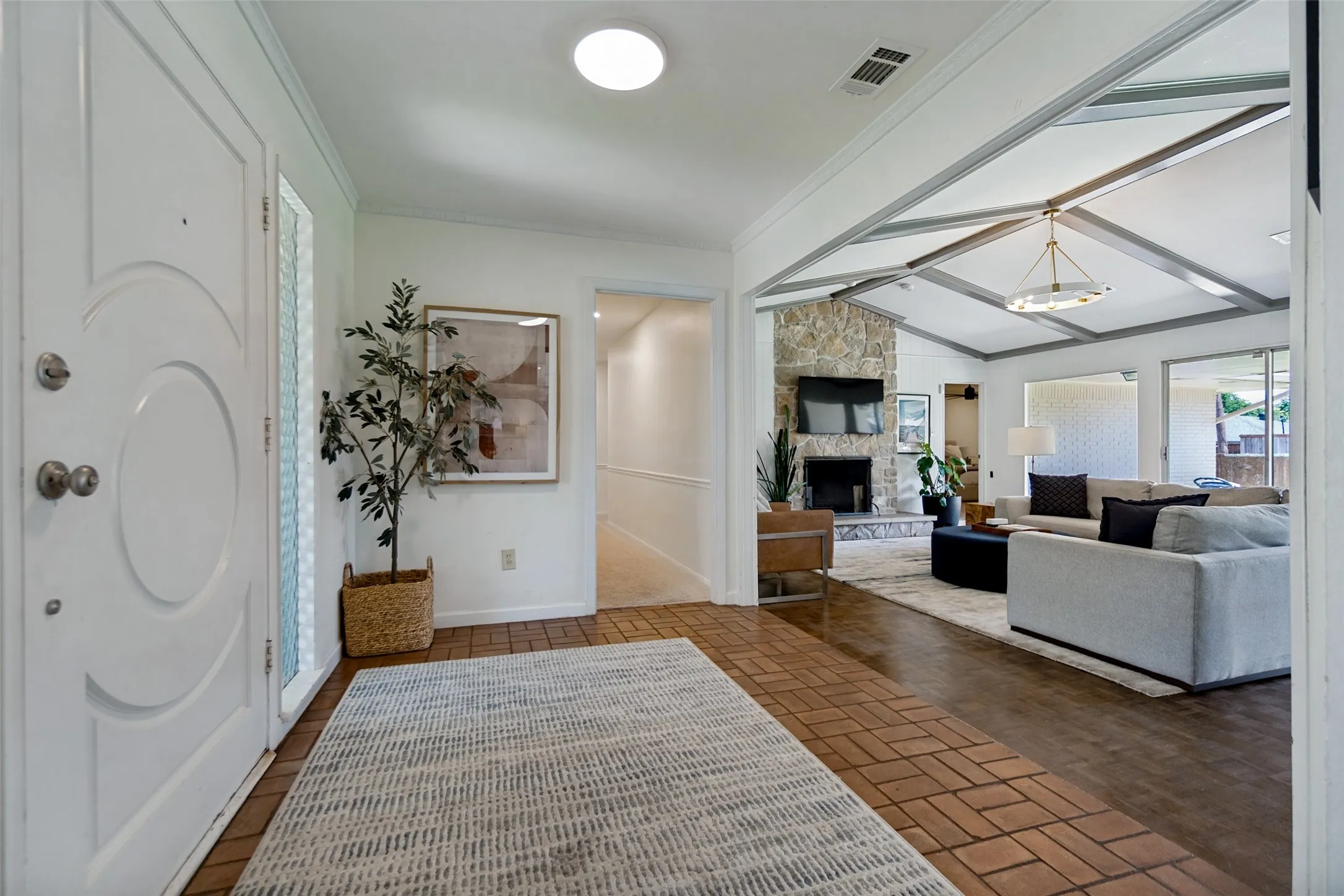 Foyer with brick-pattern flooring and a decorative front door