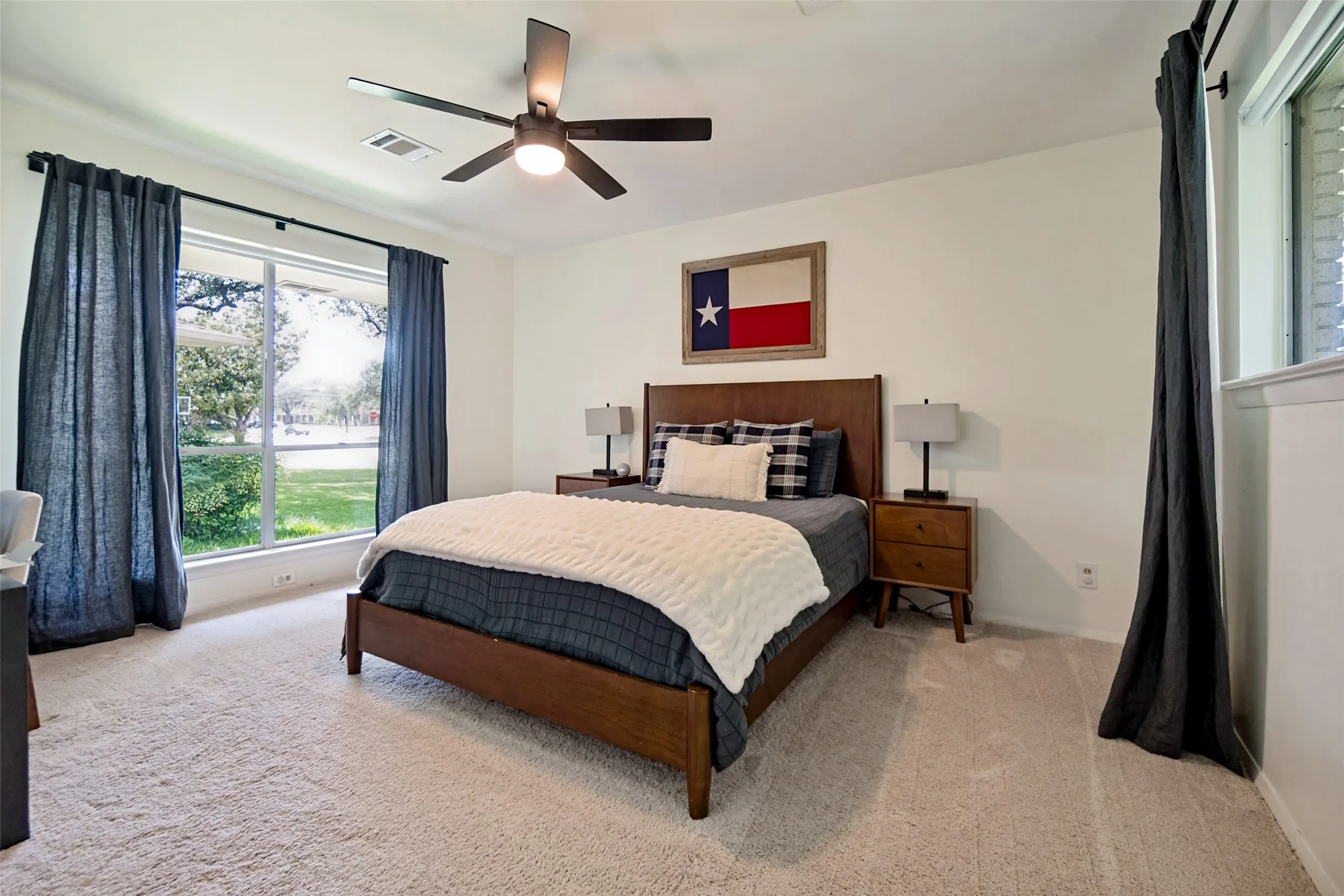 Carpeted flooring, contemporary ceiling fan, large window, and light-toned walls