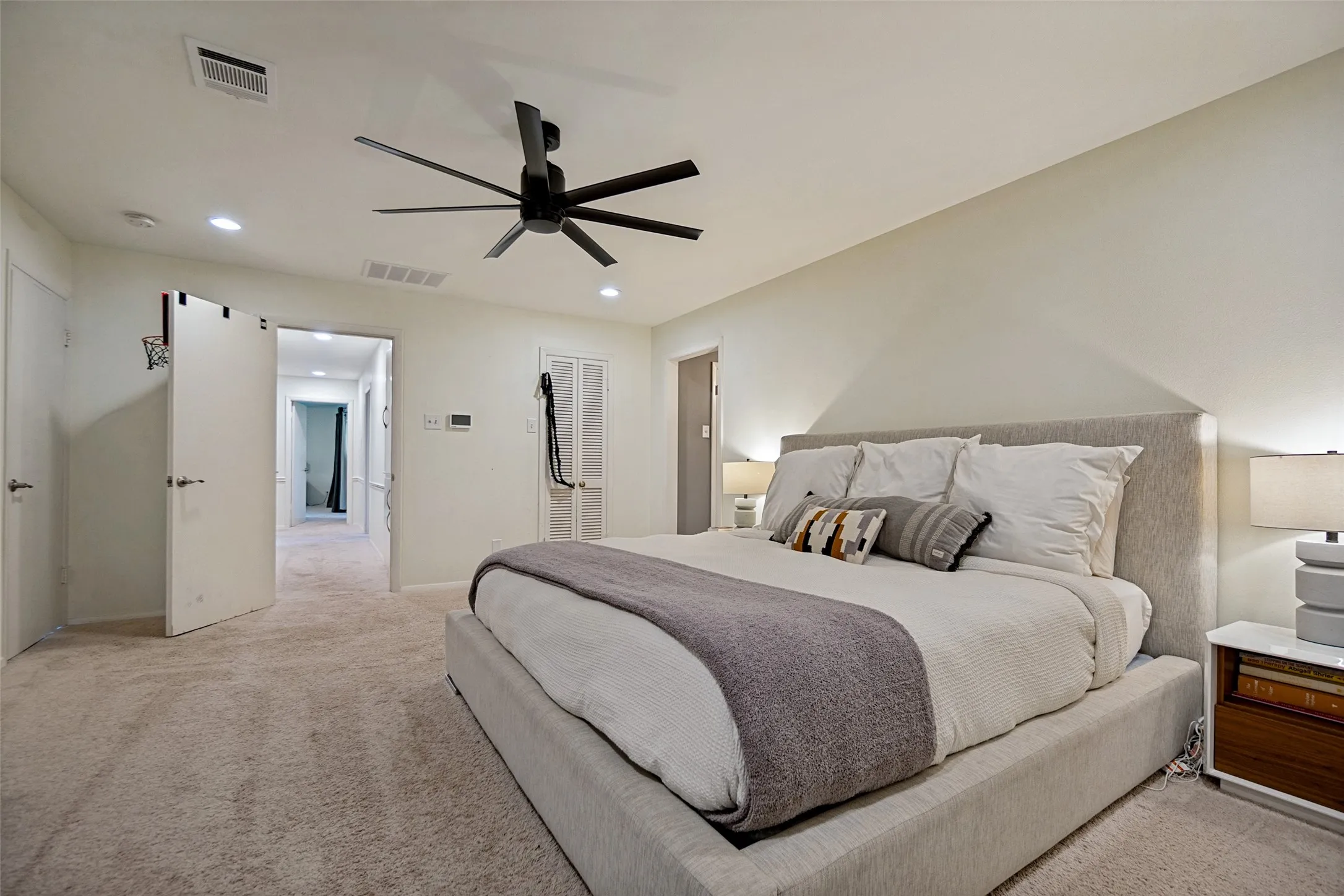 Carpeted flooring throughout, recessed lighting, and a modern ceiling fan