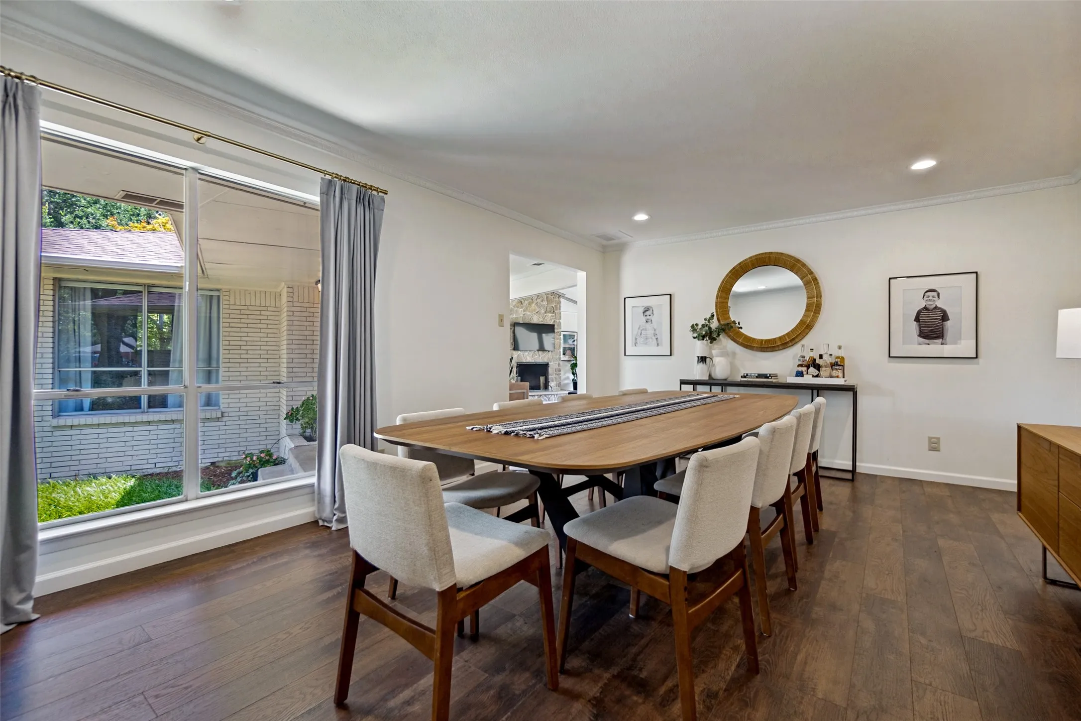 Expansive room with dark wood-finish flooring, recessed lighting, and a large window
