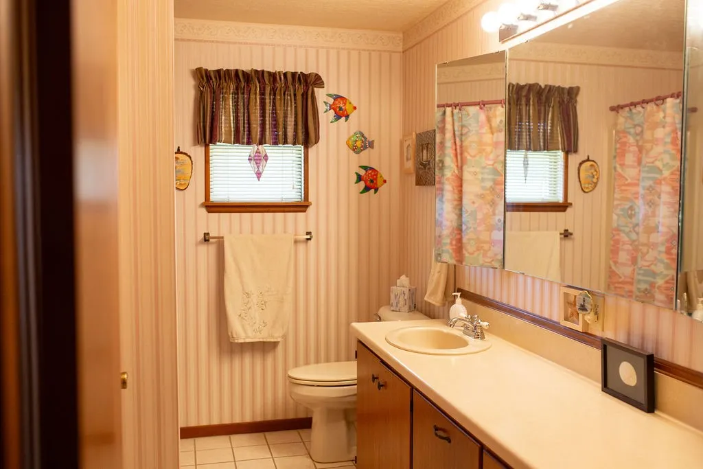 Full-width vanity with integrated sink, wood-finish cabinetry, and a mirrored medicine cabinet