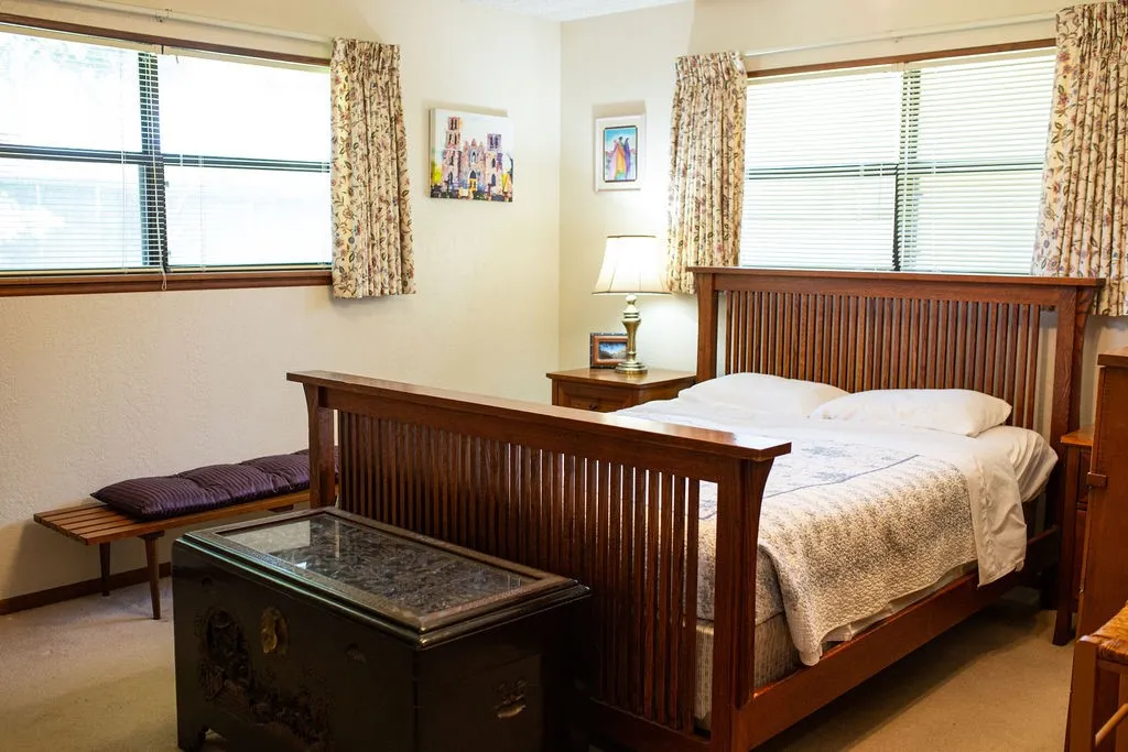 Two windows with blinds, wood-finish window trim, and wall-to-wall carpeting