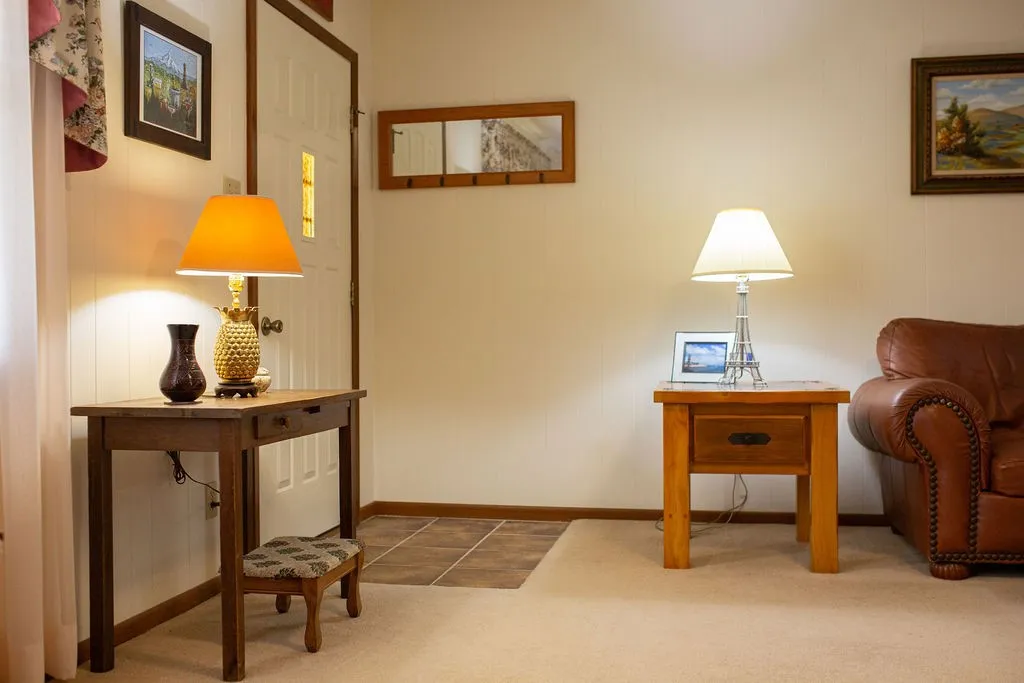 White paneled entry door with a decorative window insert and a tiled entryway