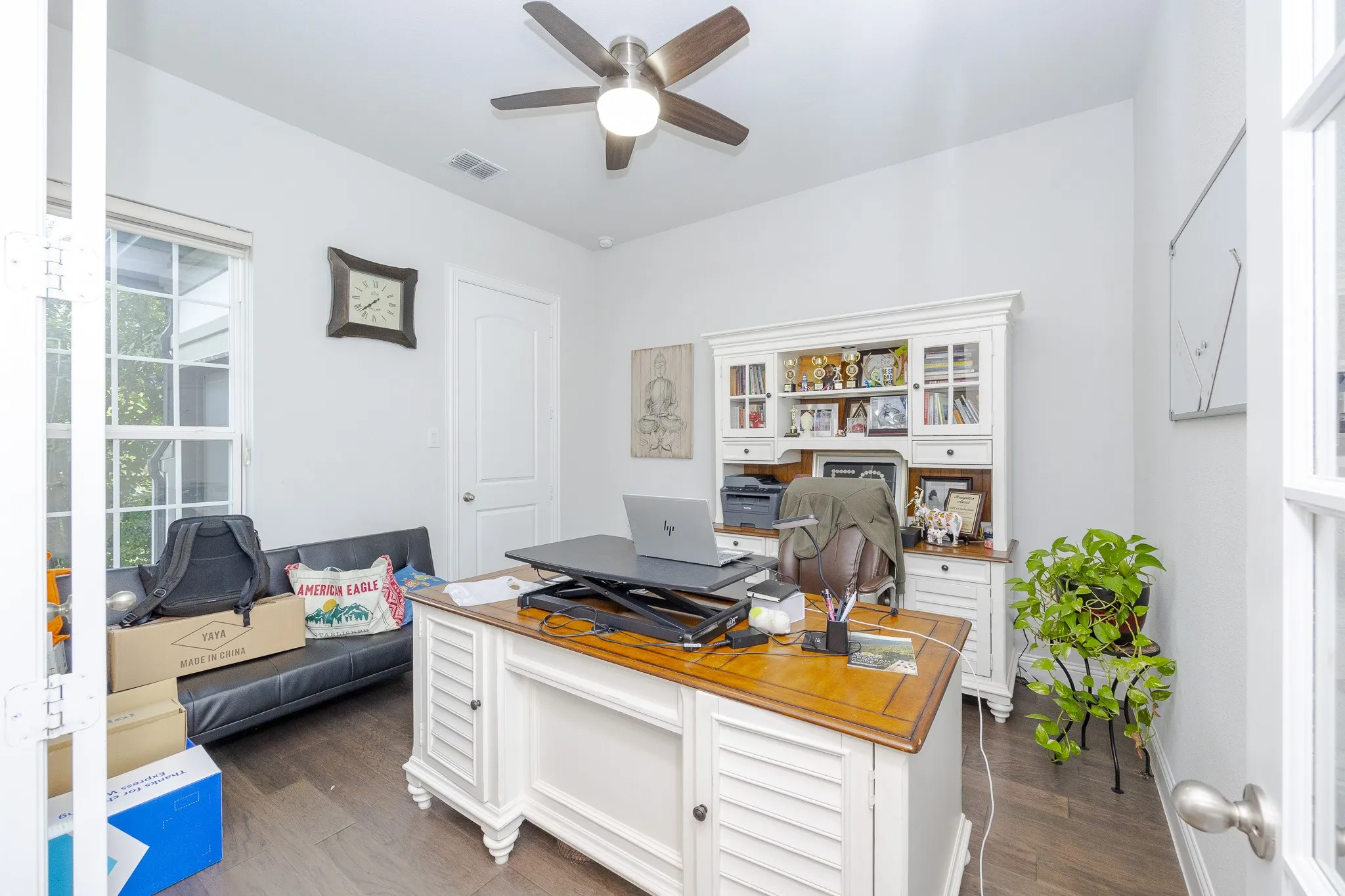 Wood-finish flooring, white walls, and a ceiling fan with light fixture