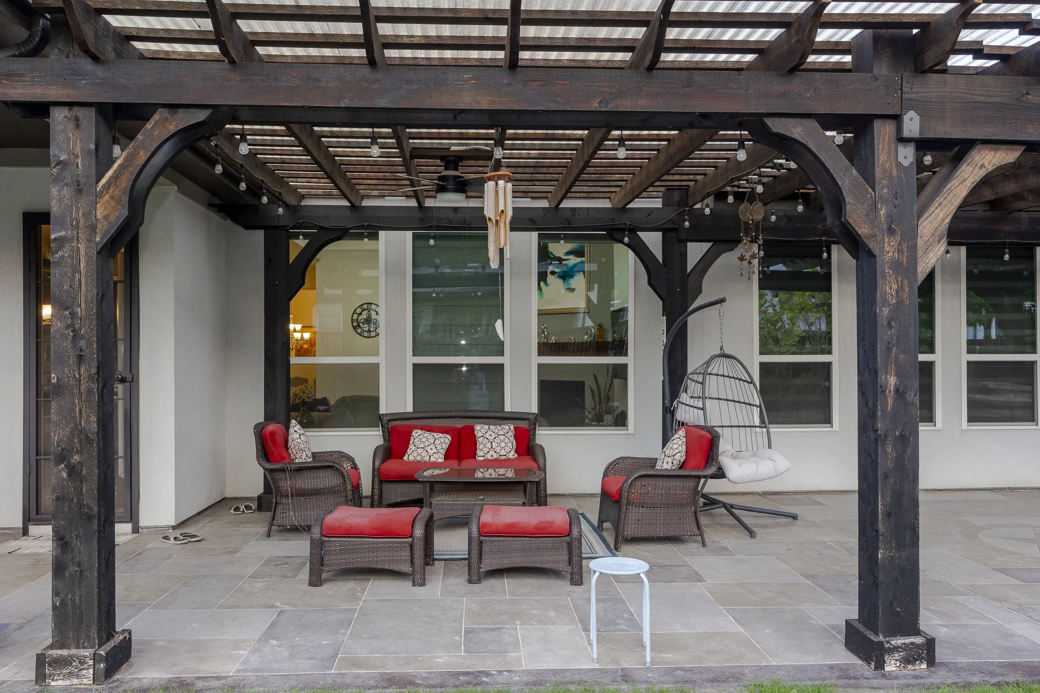 Covered patio featuring a wood pergola structure with string lights, a ceiling fan, and a tiled floor