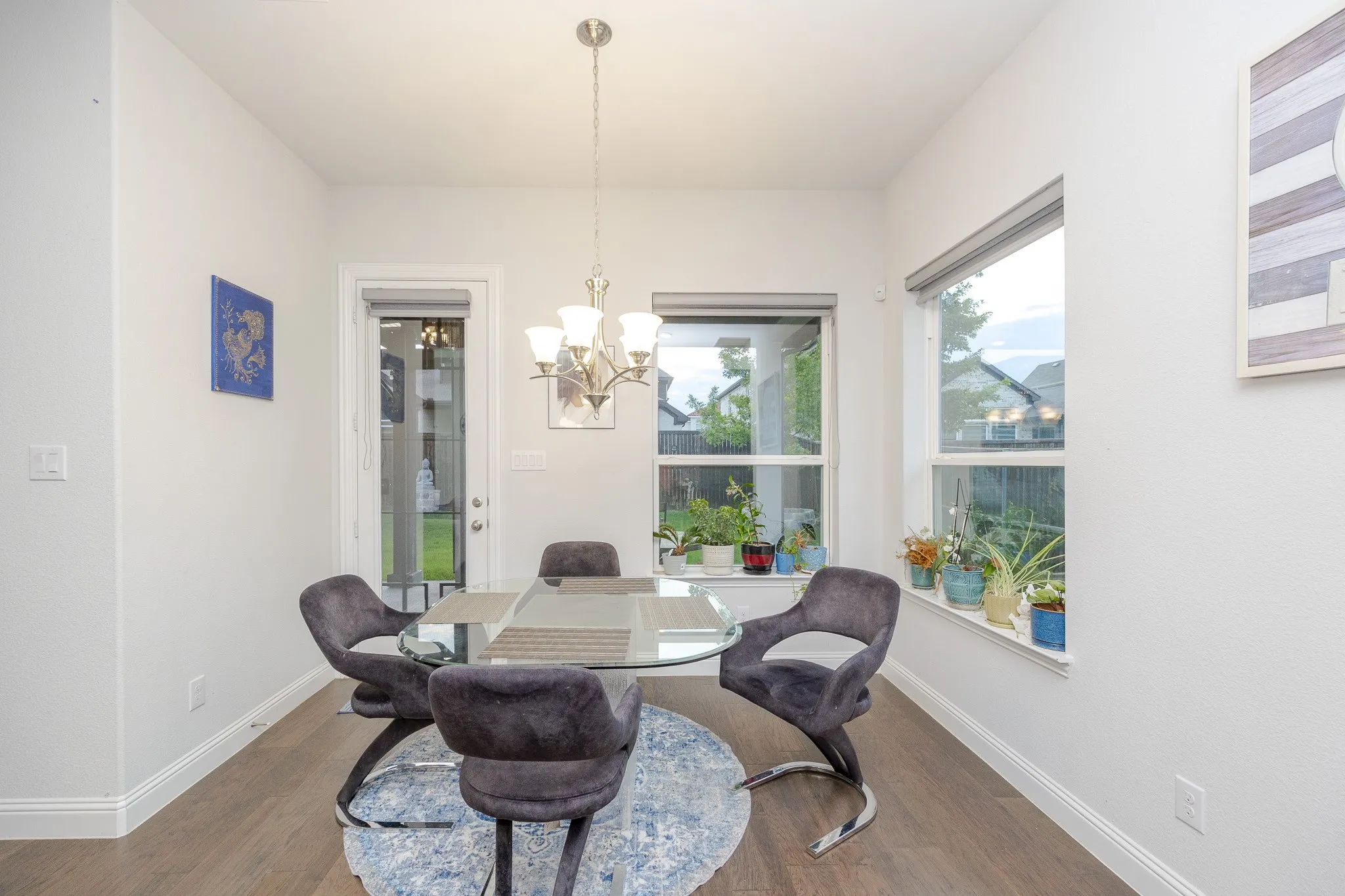 Wood-finish flooring with white baseboards, recessed lighting, and a contemporary chandelier