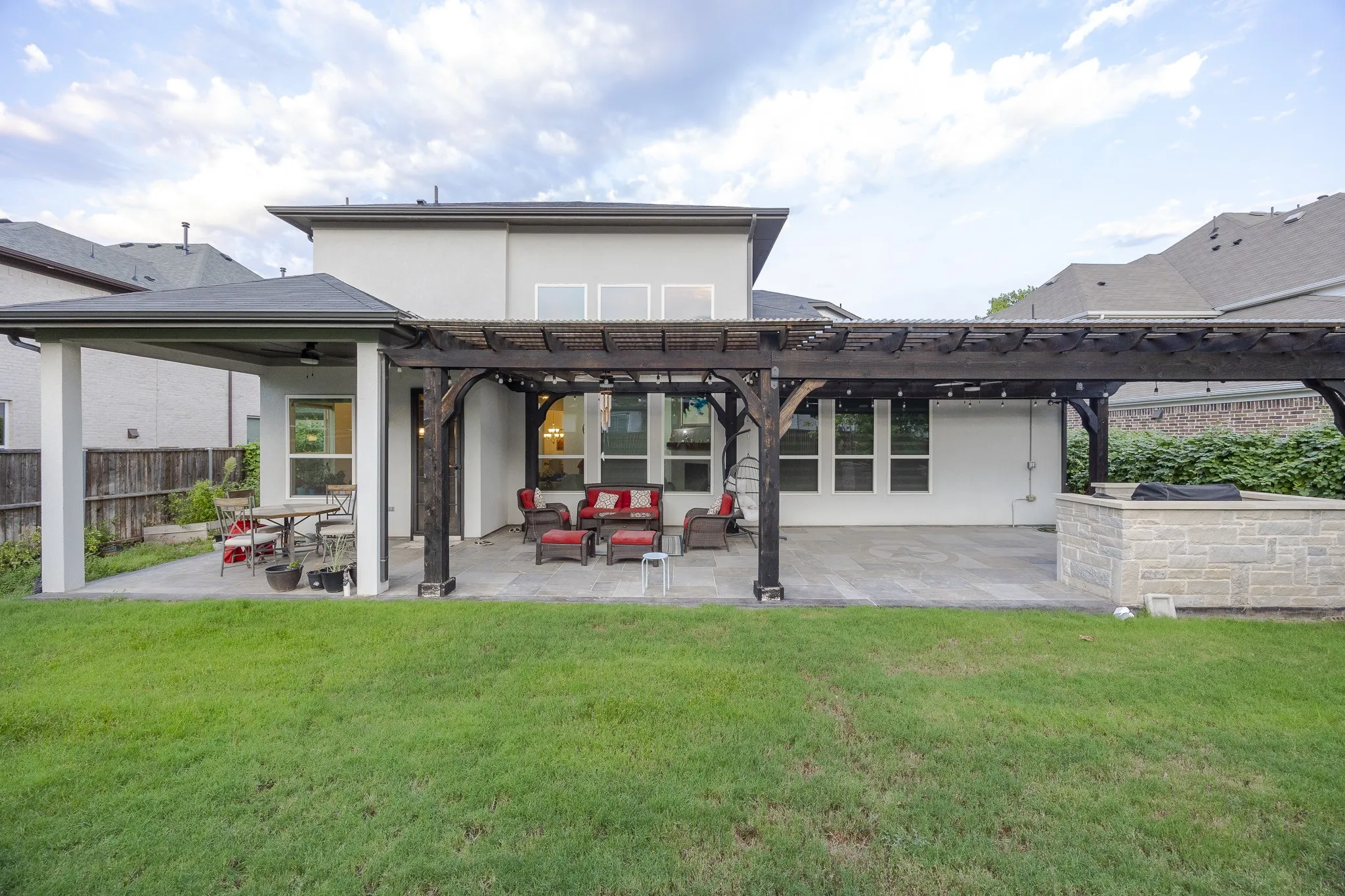 Expansive backyard featuring a lush lawn, covered patio, and a separate pergola-covered patio